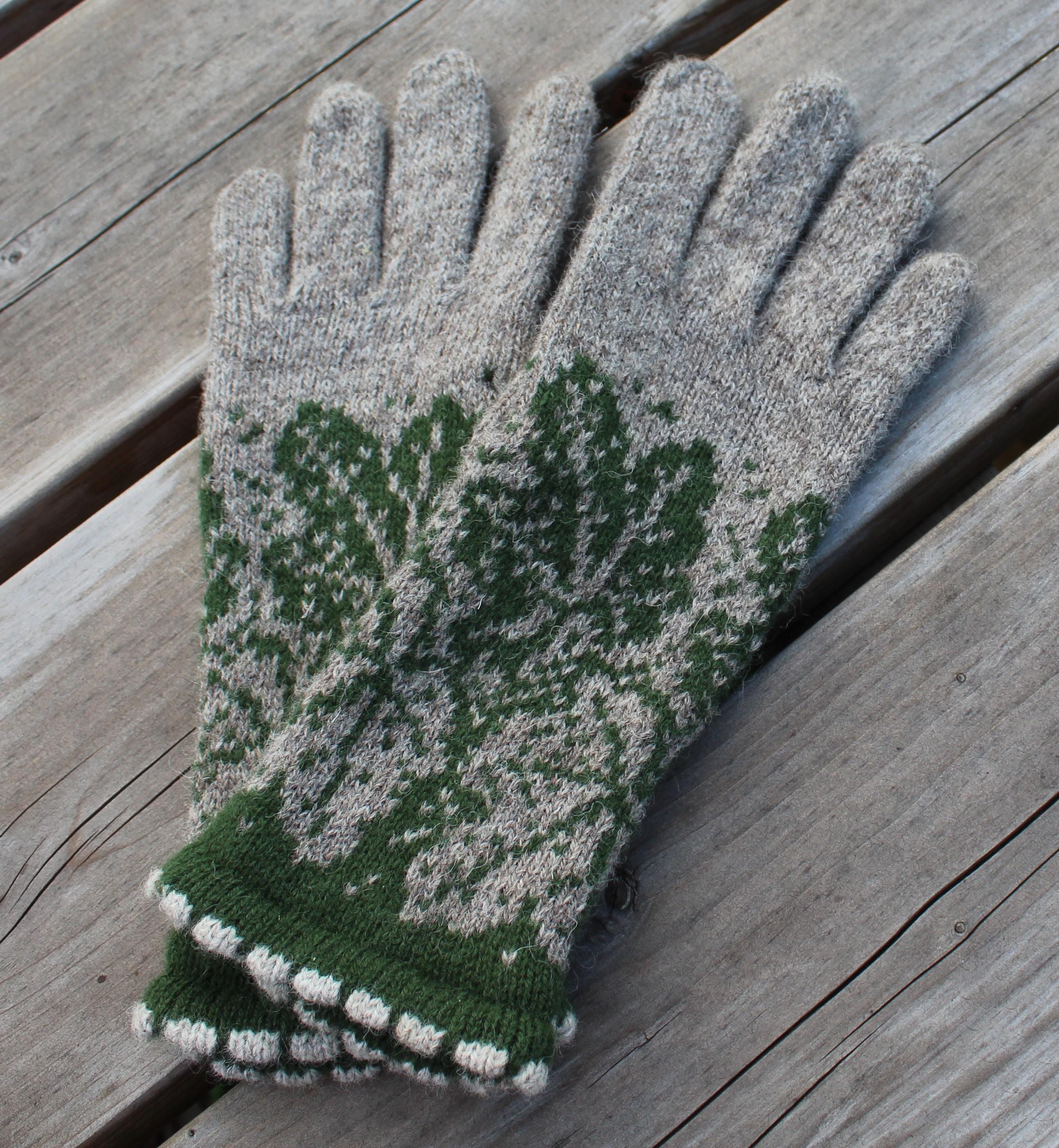 Pair of green and gray gloves on a wooden surface