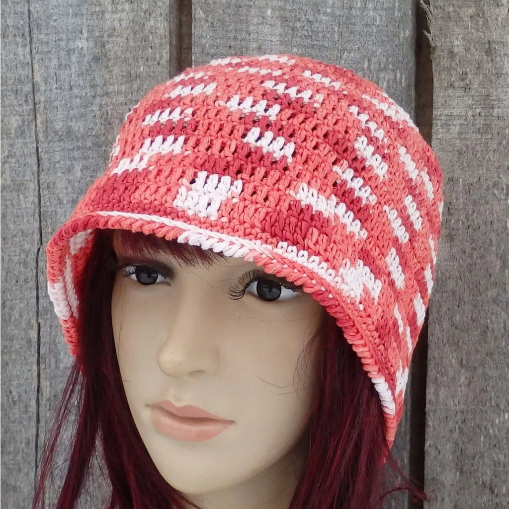 Mannequin head wearing a red and white striped knit cap against a wooden background