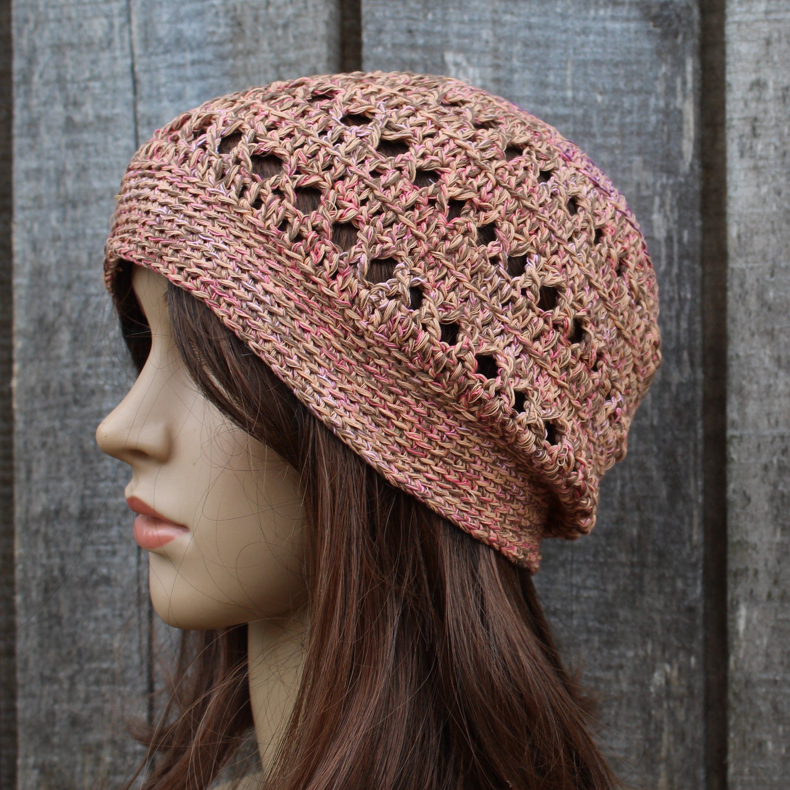 Knitted hat on a mannequin head against a wooden background