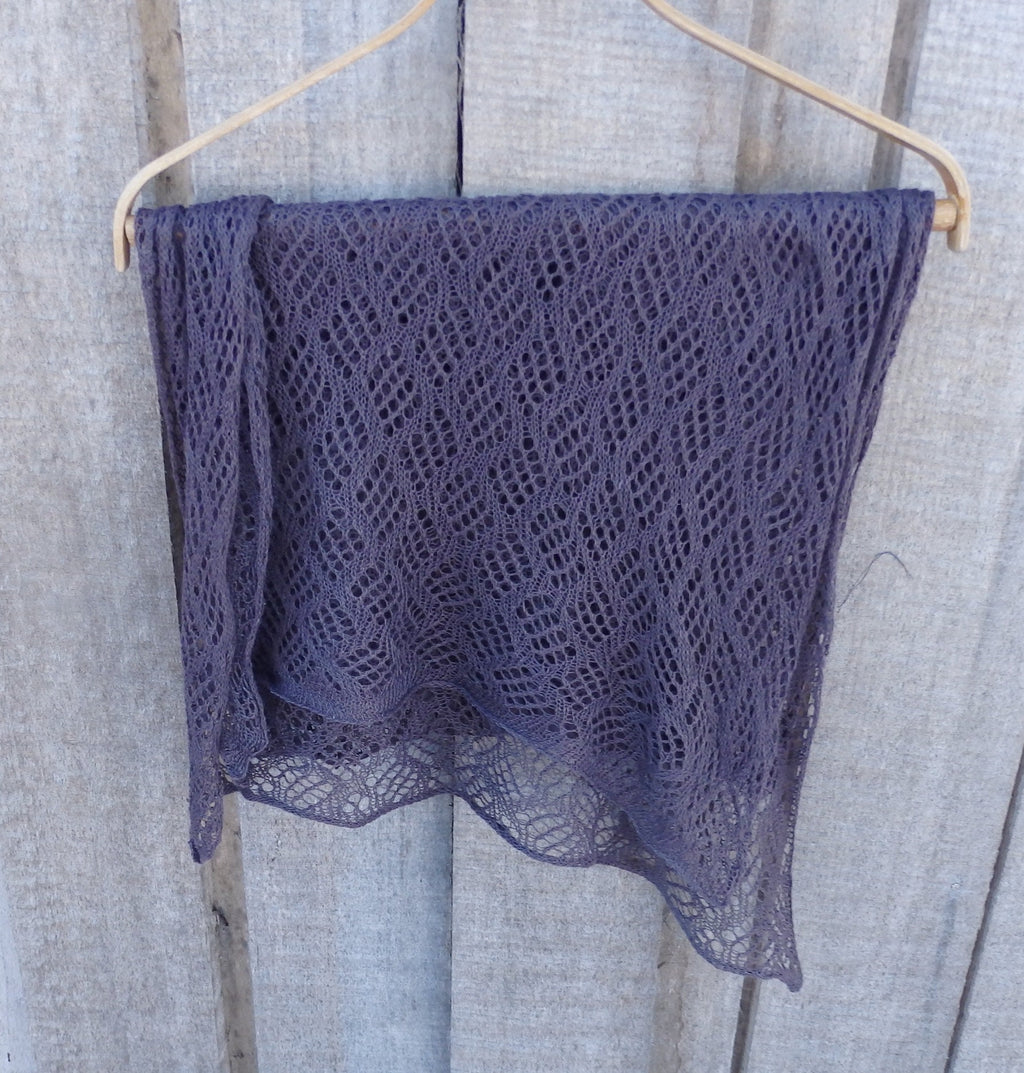 Purple lace fabric draped over a wooden surface