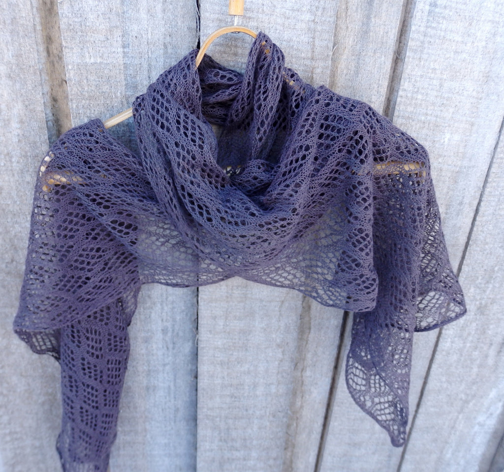 Purple lace shawl draped over a wooden surface