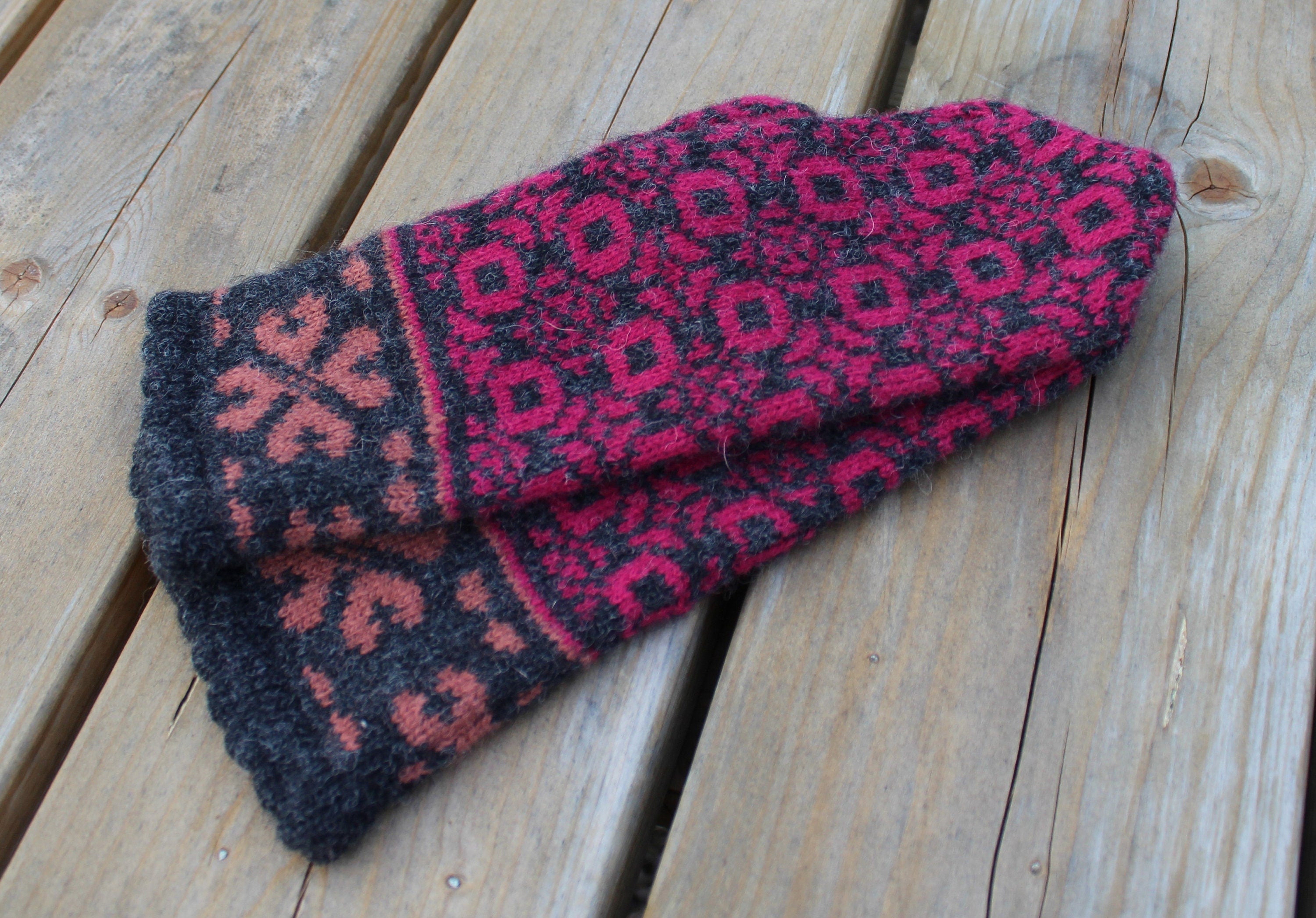 Pair of patterned mittens on a wooden surface