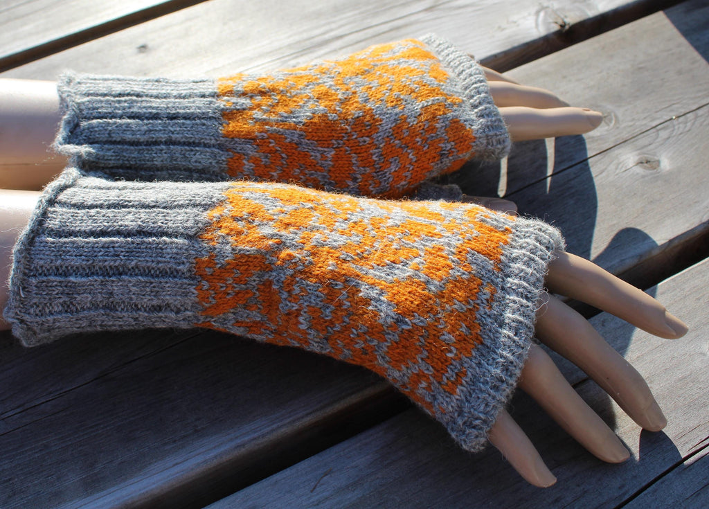 Gray and orange patterned fingerless gloves on a wooden surface