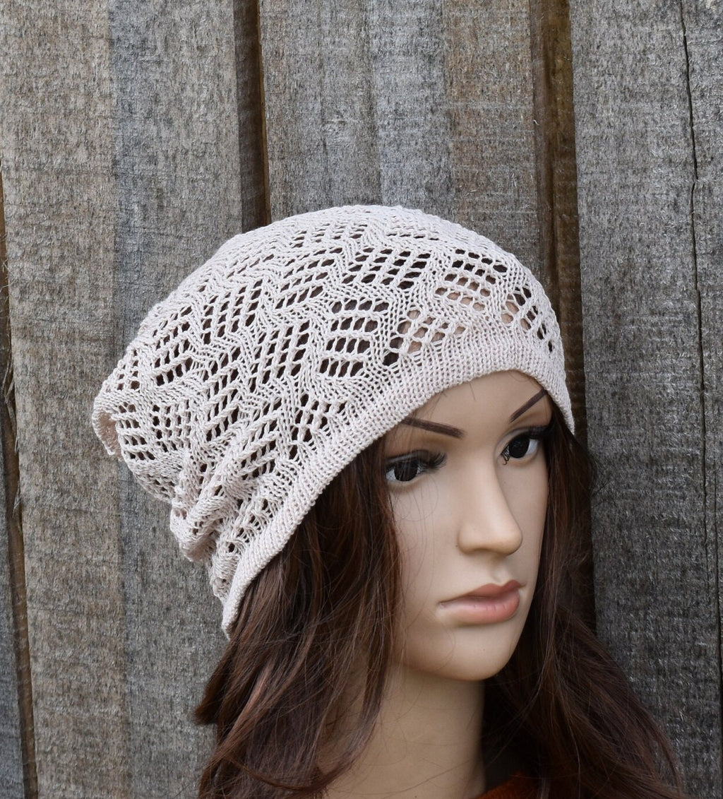 Knitted beige hat on a mannequin head against a wooden background