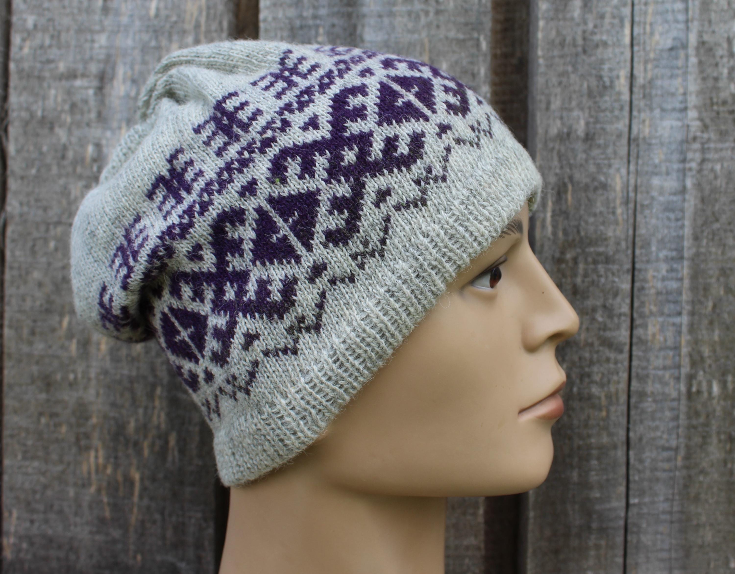 Knitted hat with purple pattern on a mannequin head against a wooden background