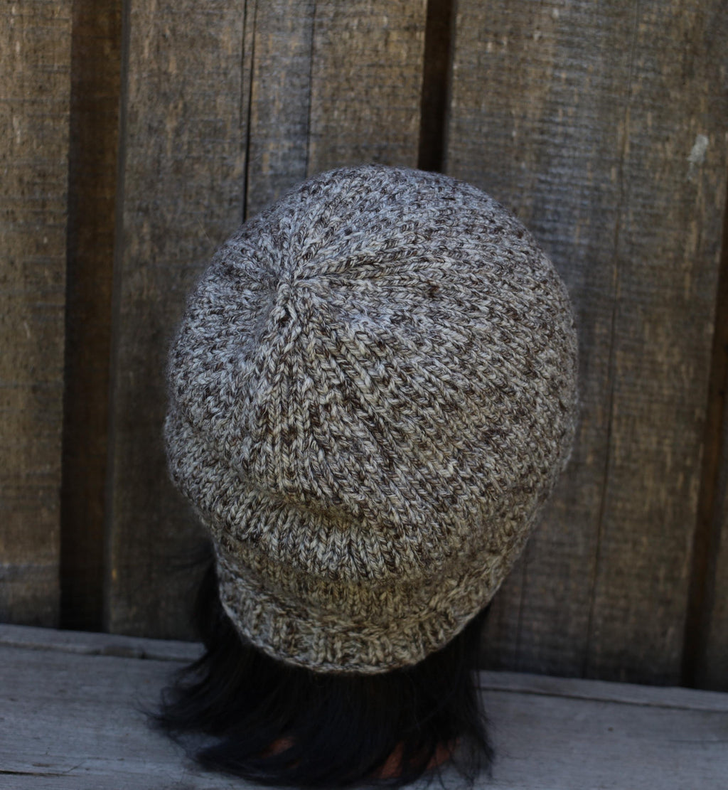 Knitted beanie on a wooden surface with a wooden panel background
