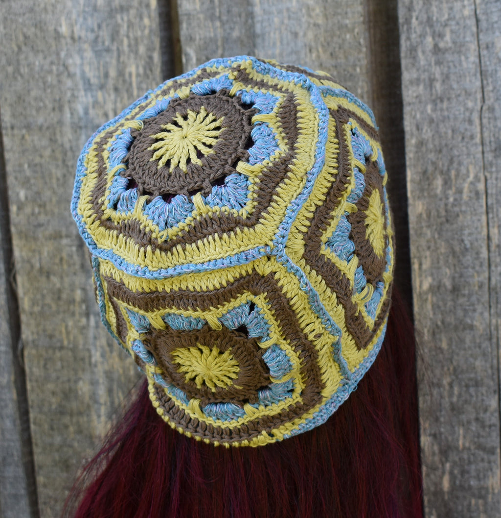 Colorful crocheted hat with geometric pattern against a wooden background