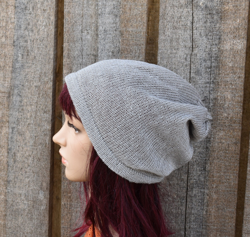 Gray knit beanie on a mannequin head against a wooden background