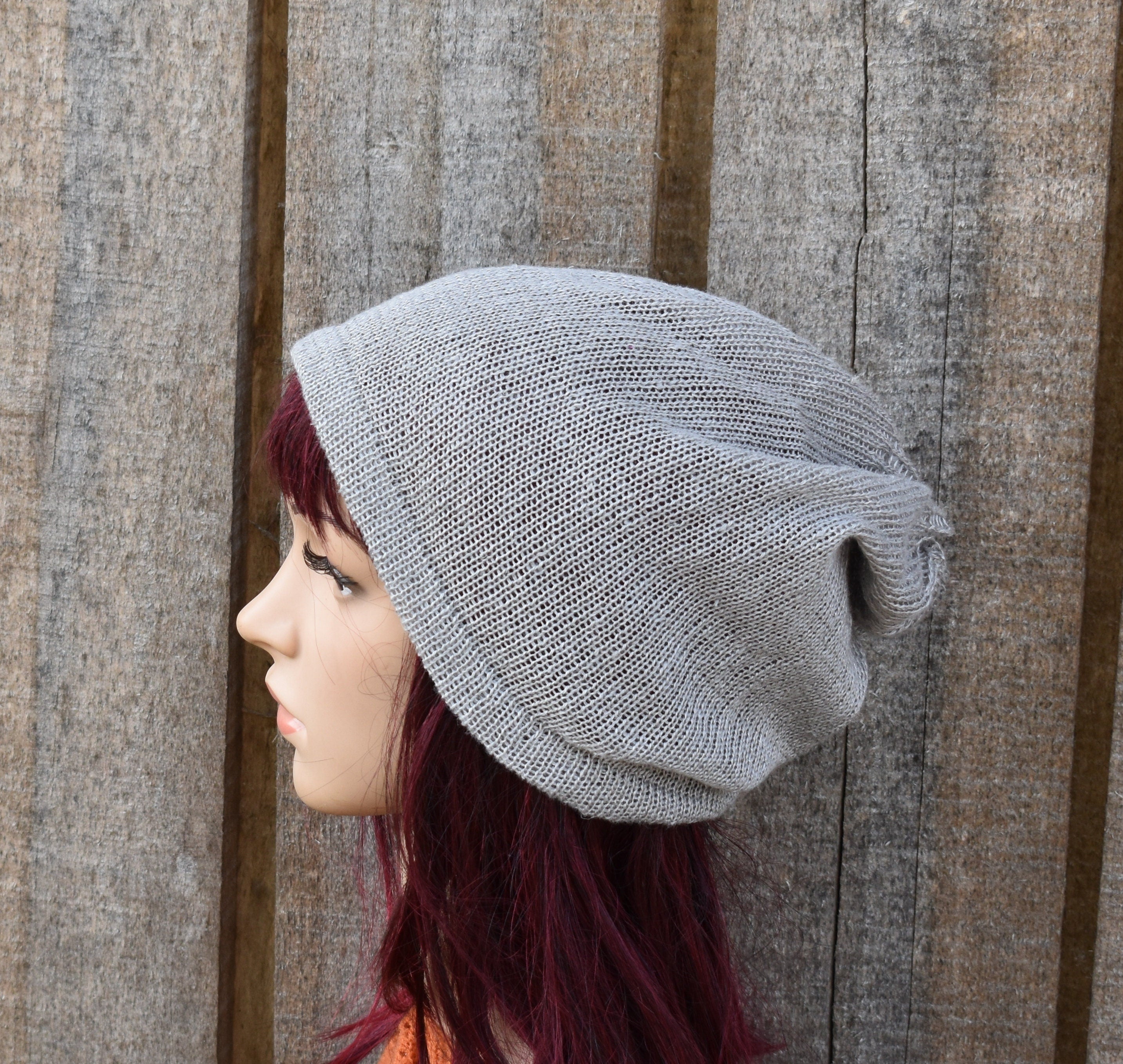 Gray knit beanie on a mannequin head against a wooden background