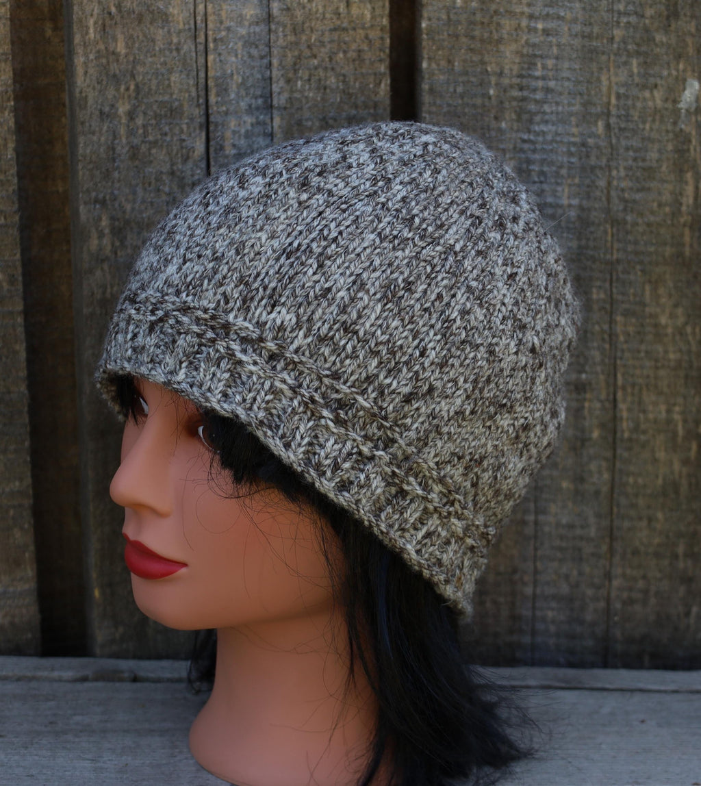 Knitted beanie on a mannequin head against a wooden background