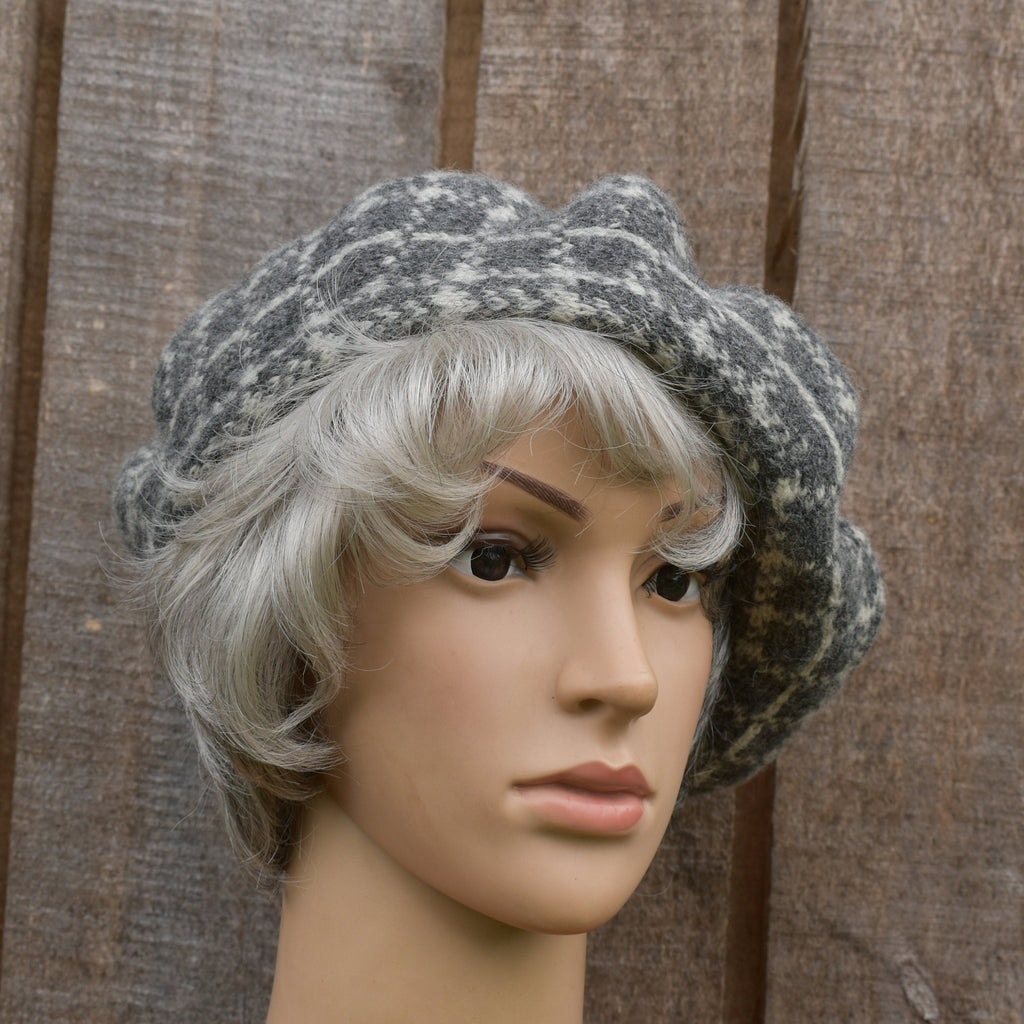 Mannequin head with gray knit hat and white wig against a wooden background