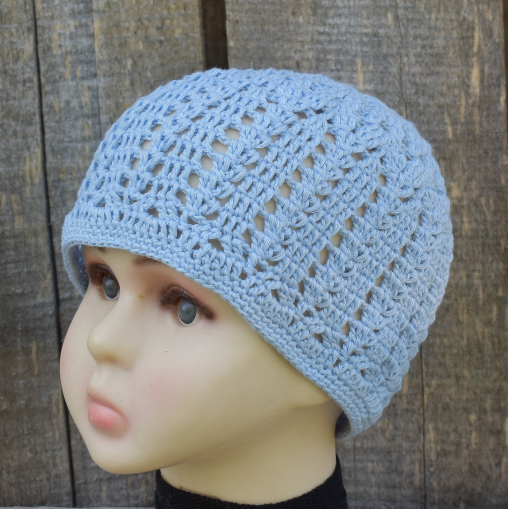 Light blue knitted hat on a mannequin head against a wooden background