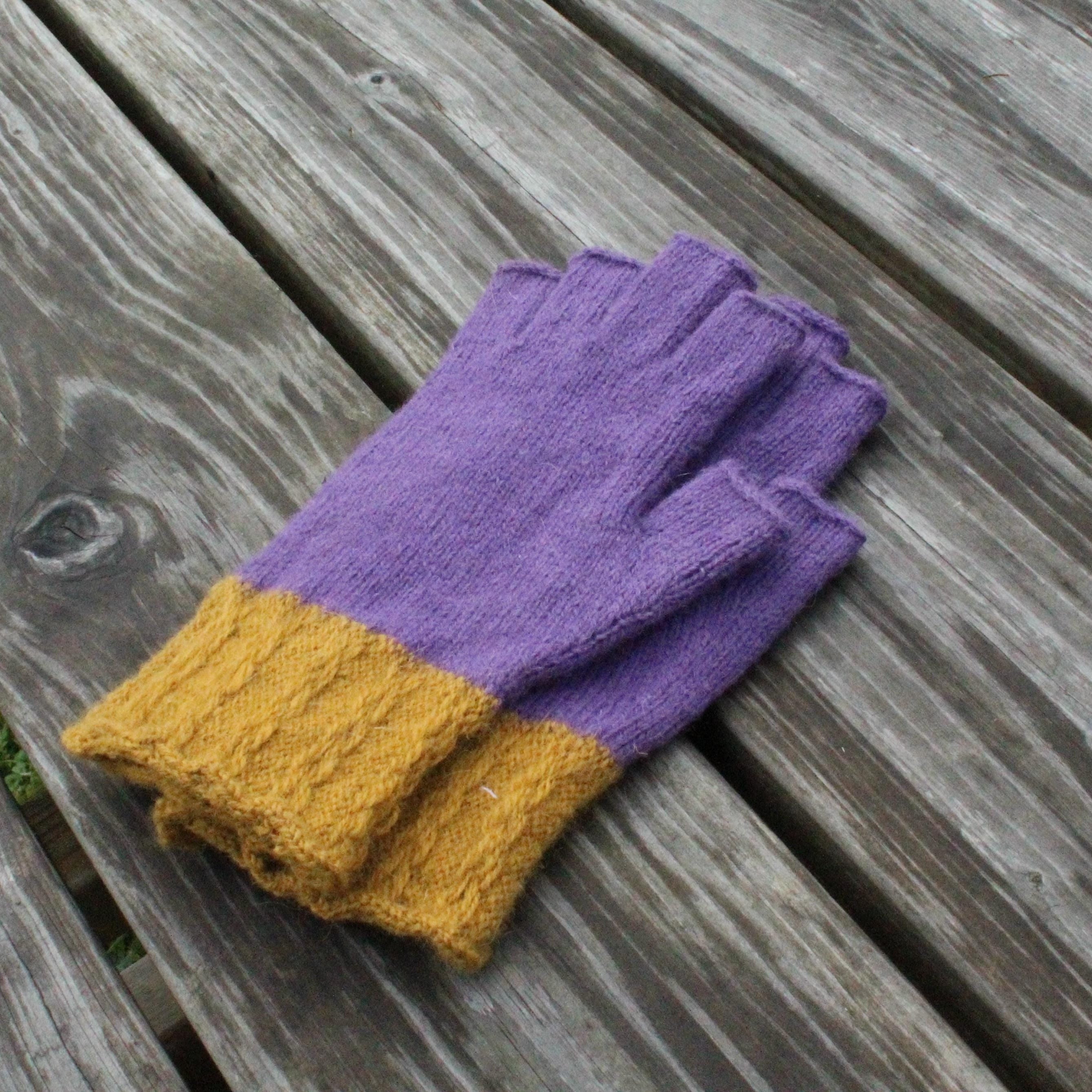 Purple gloves with yellow cuffs on a wooden surface