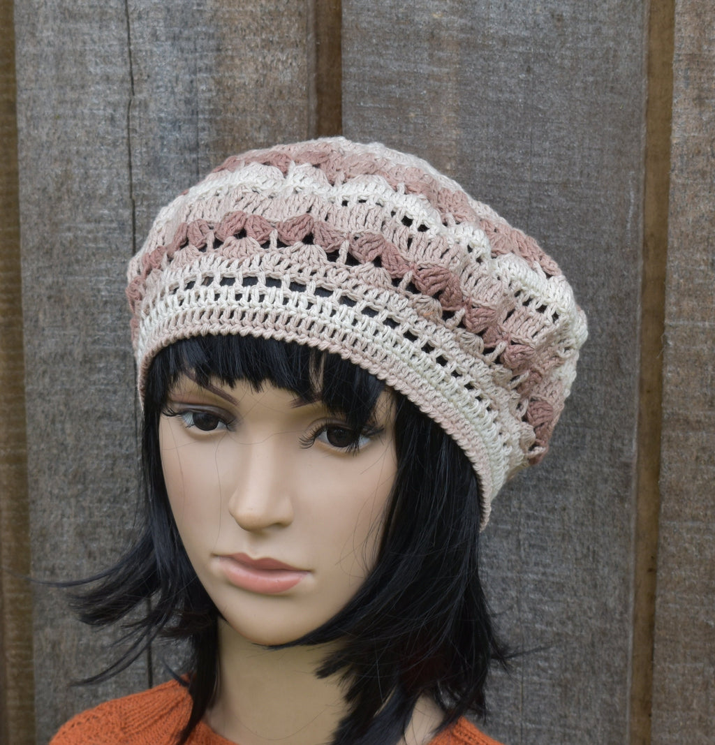 Mannequin head wearing a crocheted beanie with a textured background