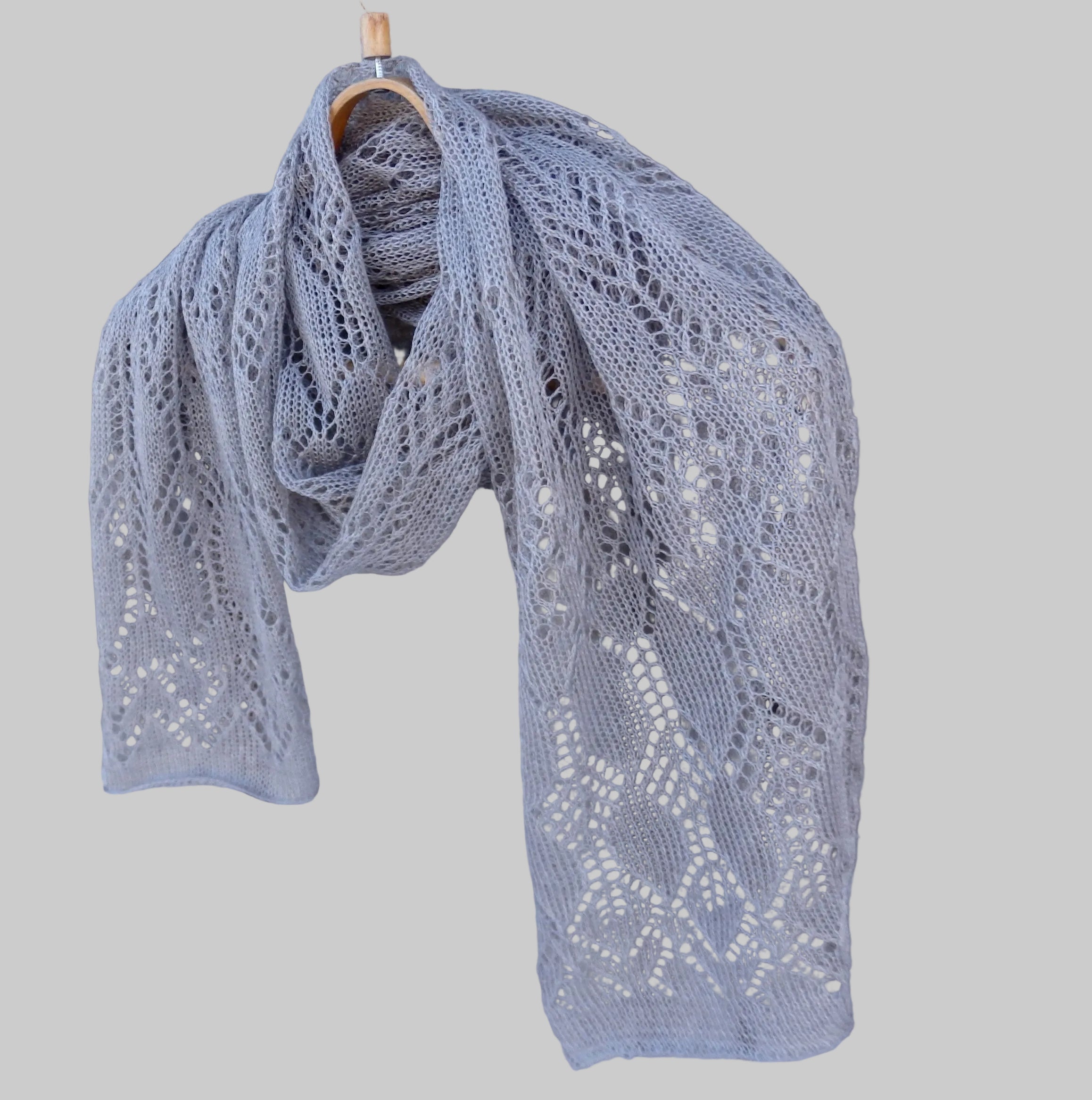 Knitted gray scarf draped over a wooden surface