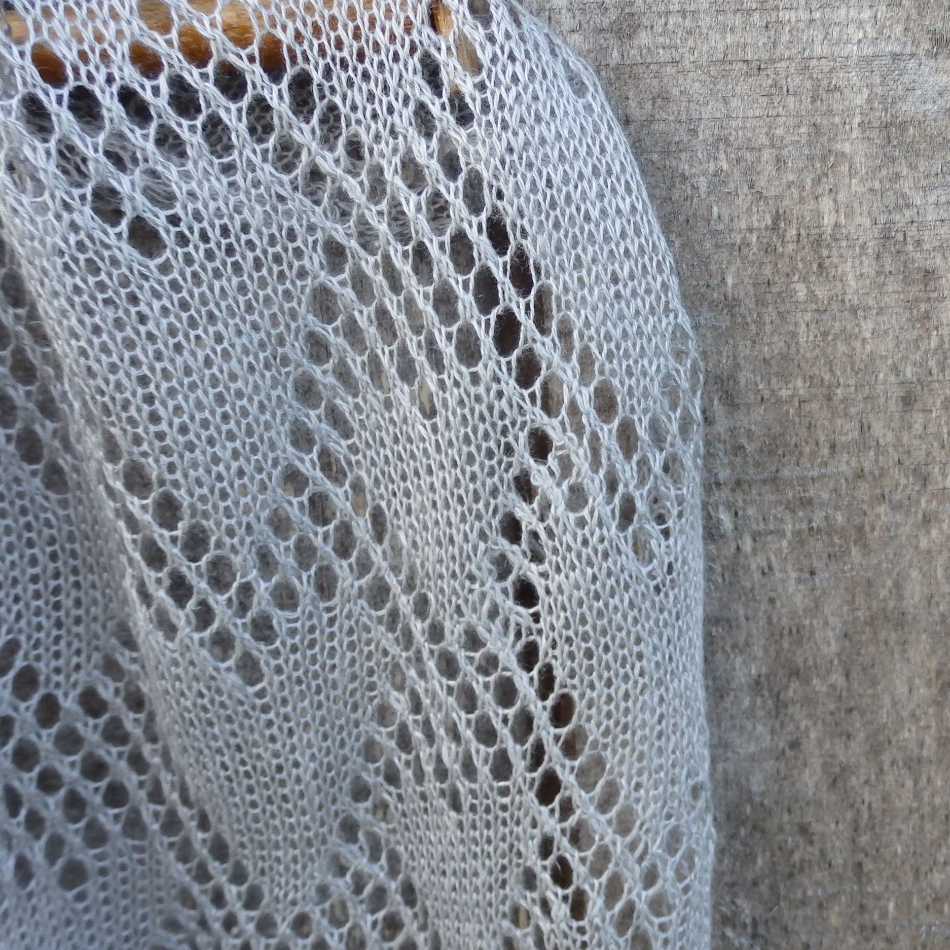 Close-up of a textured fabric with a lace-like pattern against a neutral background
