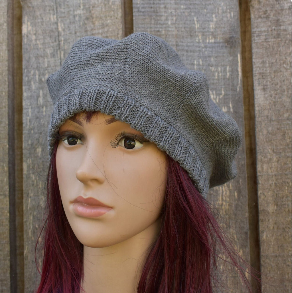 Gray knit beanie on a mannequin head with wooden background