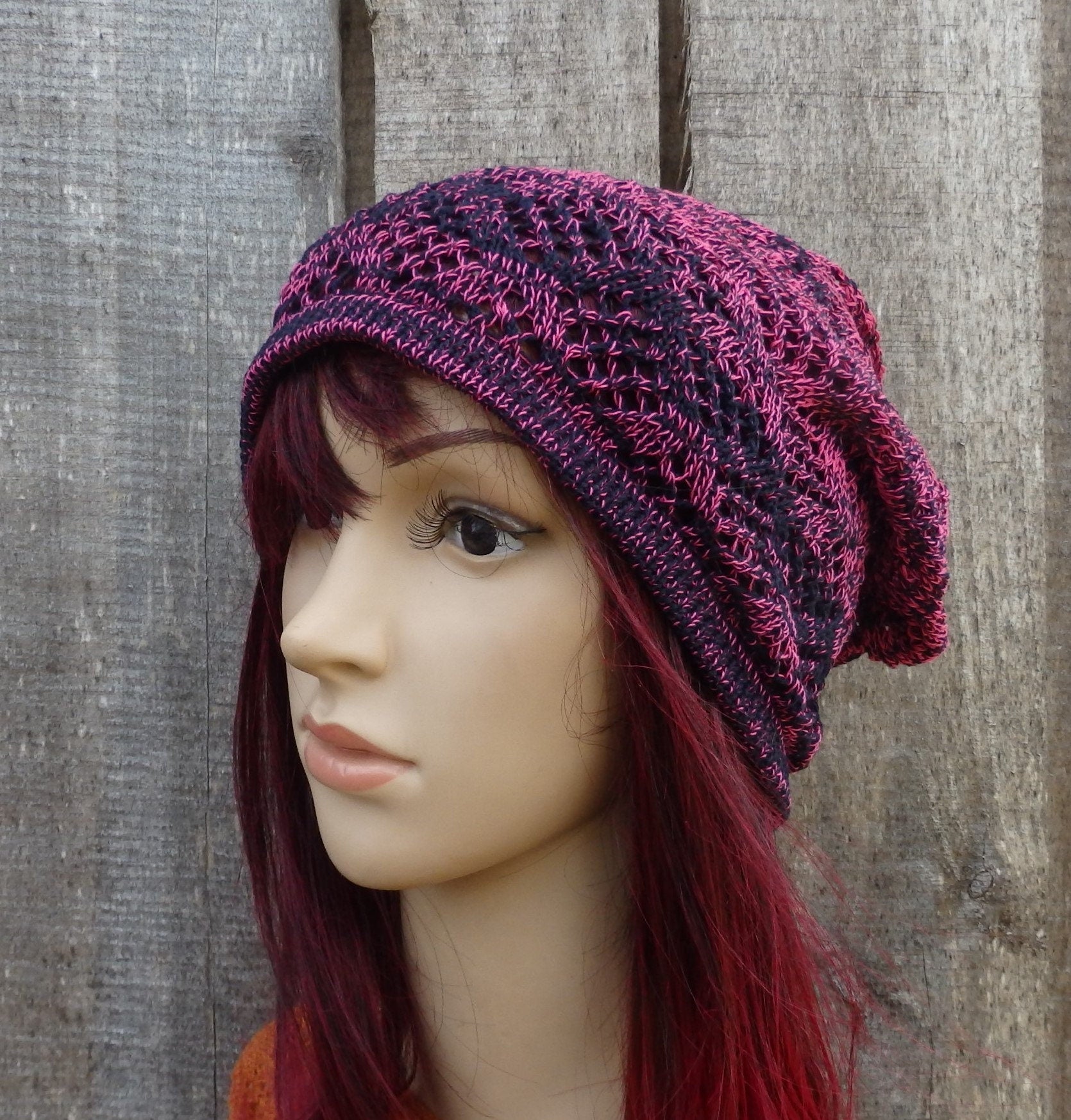 Knitted purple beanie on a mannequin head against a wooden background