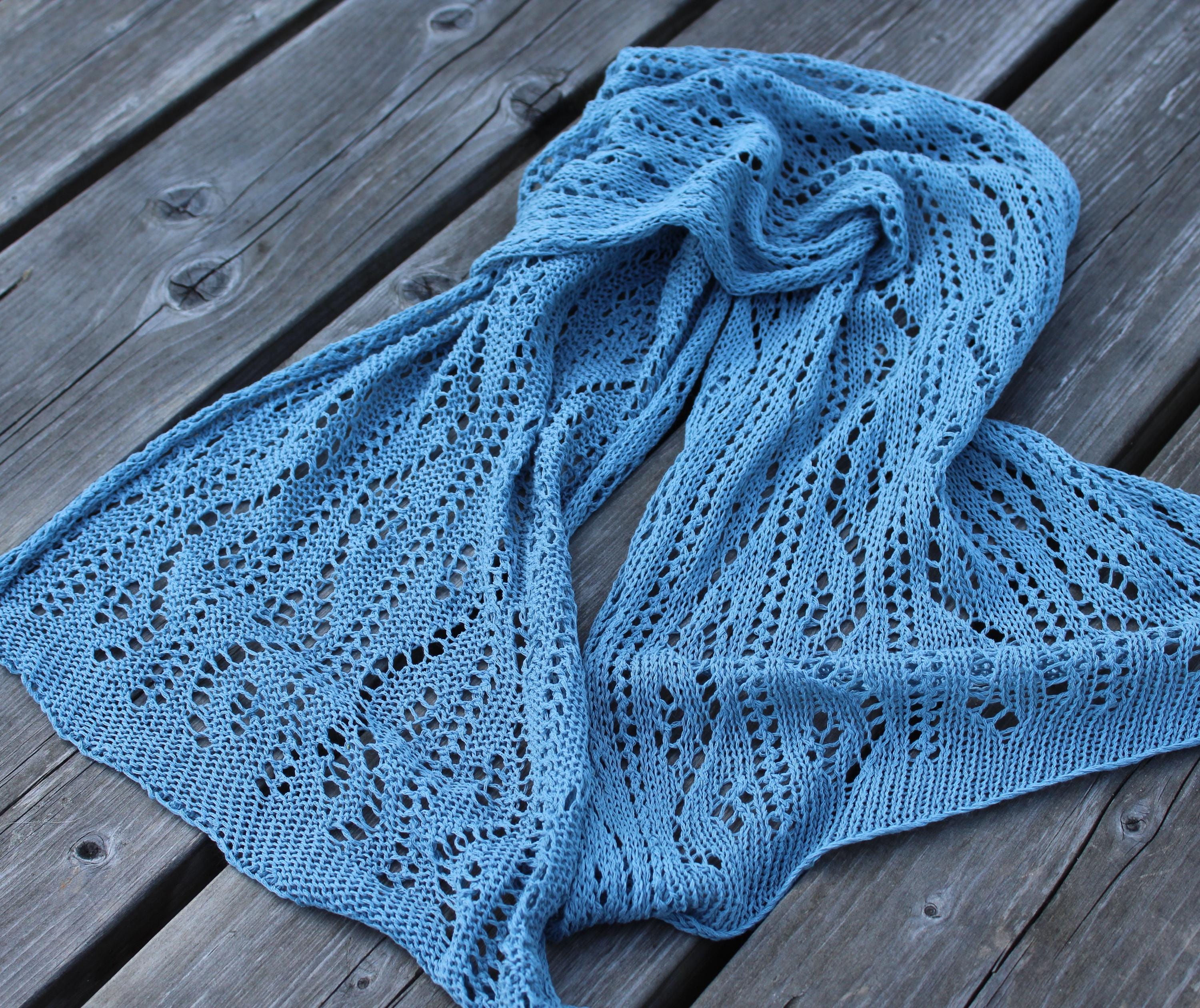 Blue knitted shawl on a wooden surface