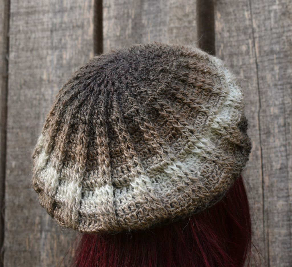 Knitted beanie with a textured pattern against a wooden background