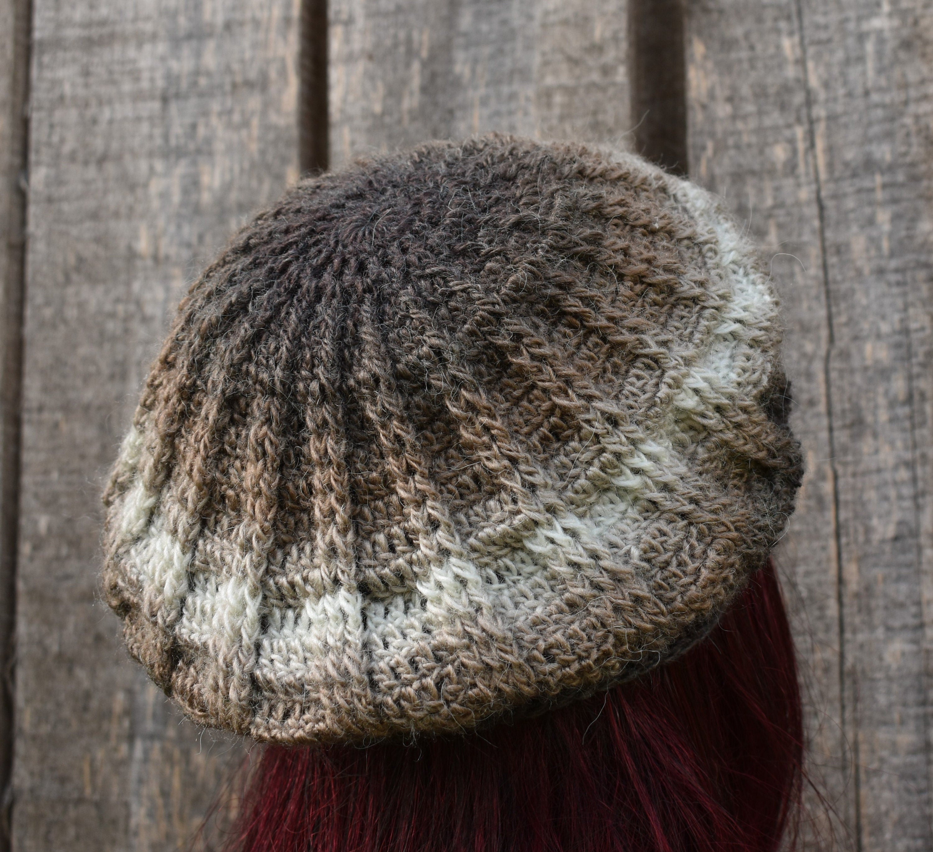 Knitted beanie with a textured pattern against a wooden background