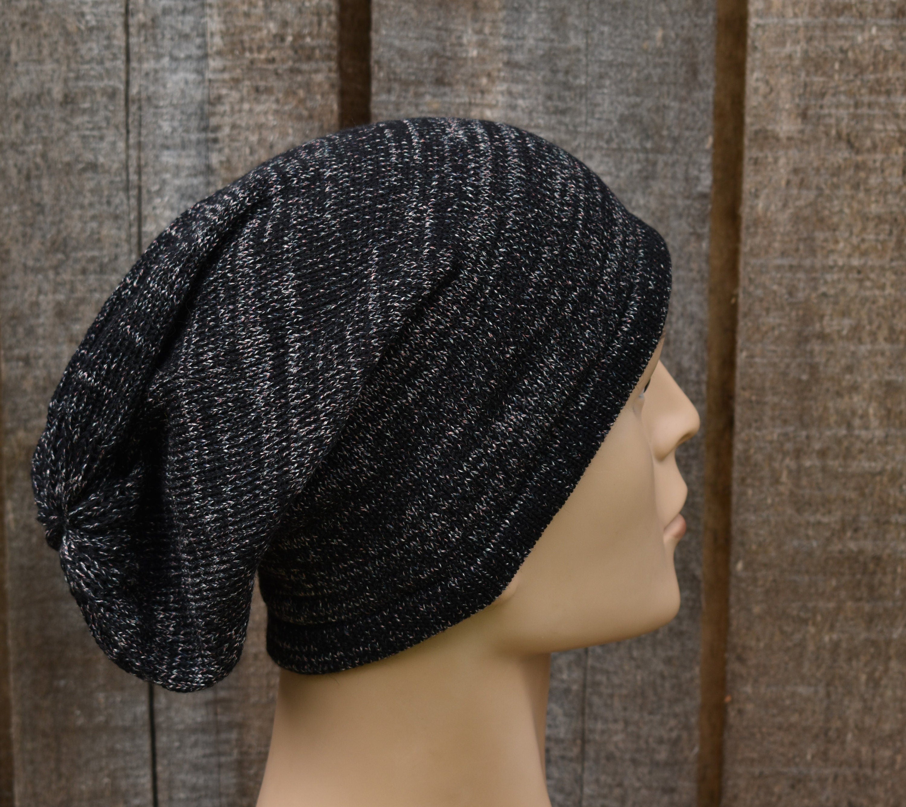 Black knit beanie on a mannequin head against a wooden background