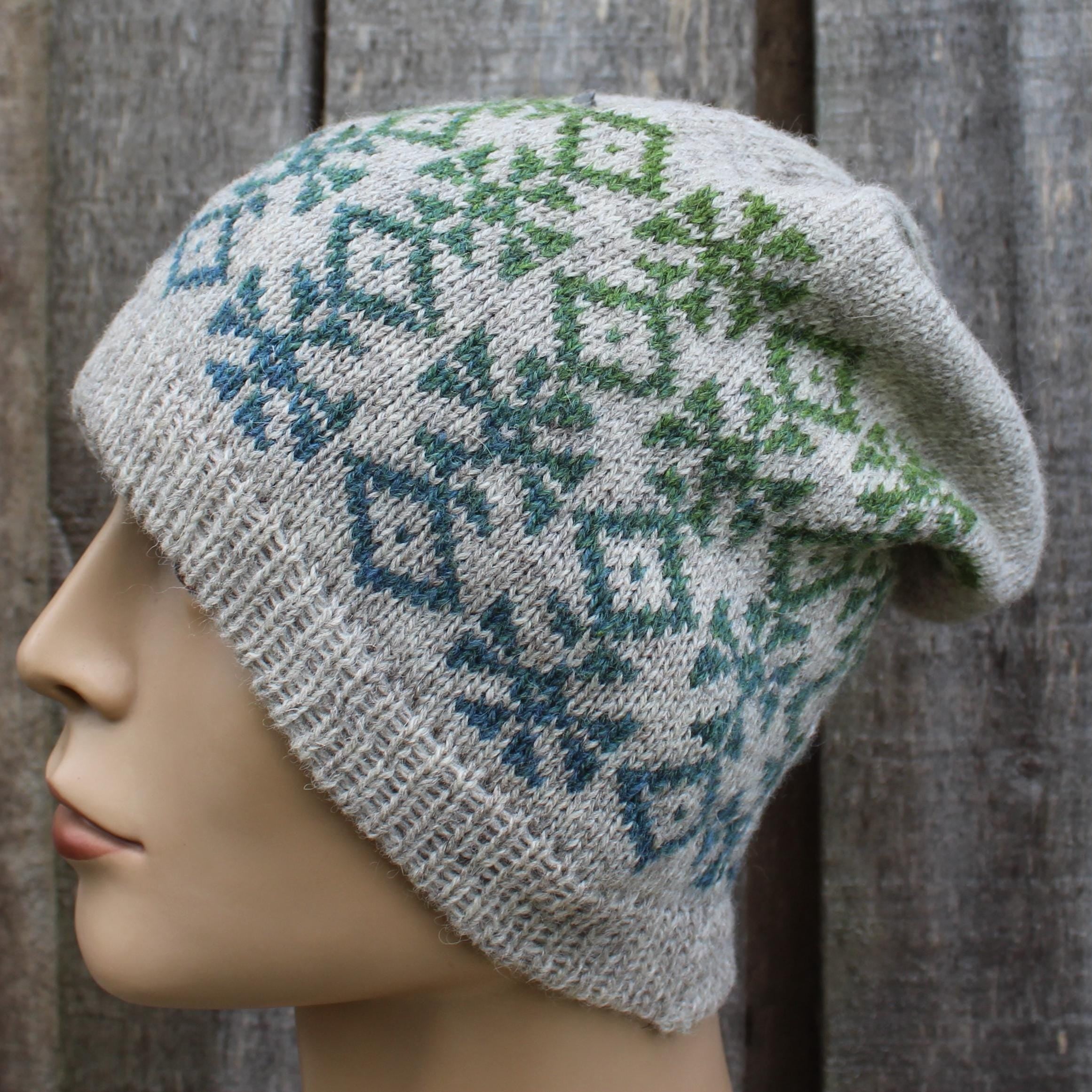 Knitted hat with a geometric pattern on a mannequin head against a wooden background