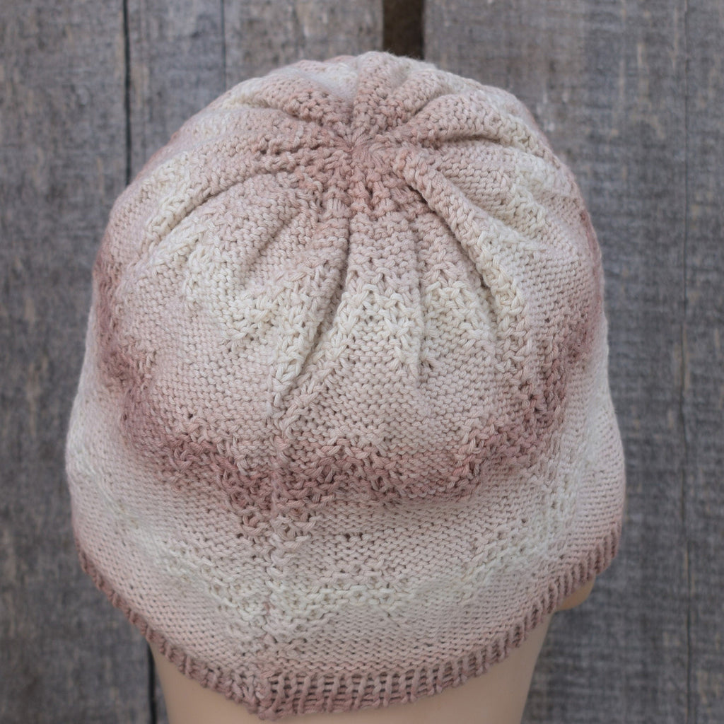 Knitted cap on a mannequin head against a wooden background