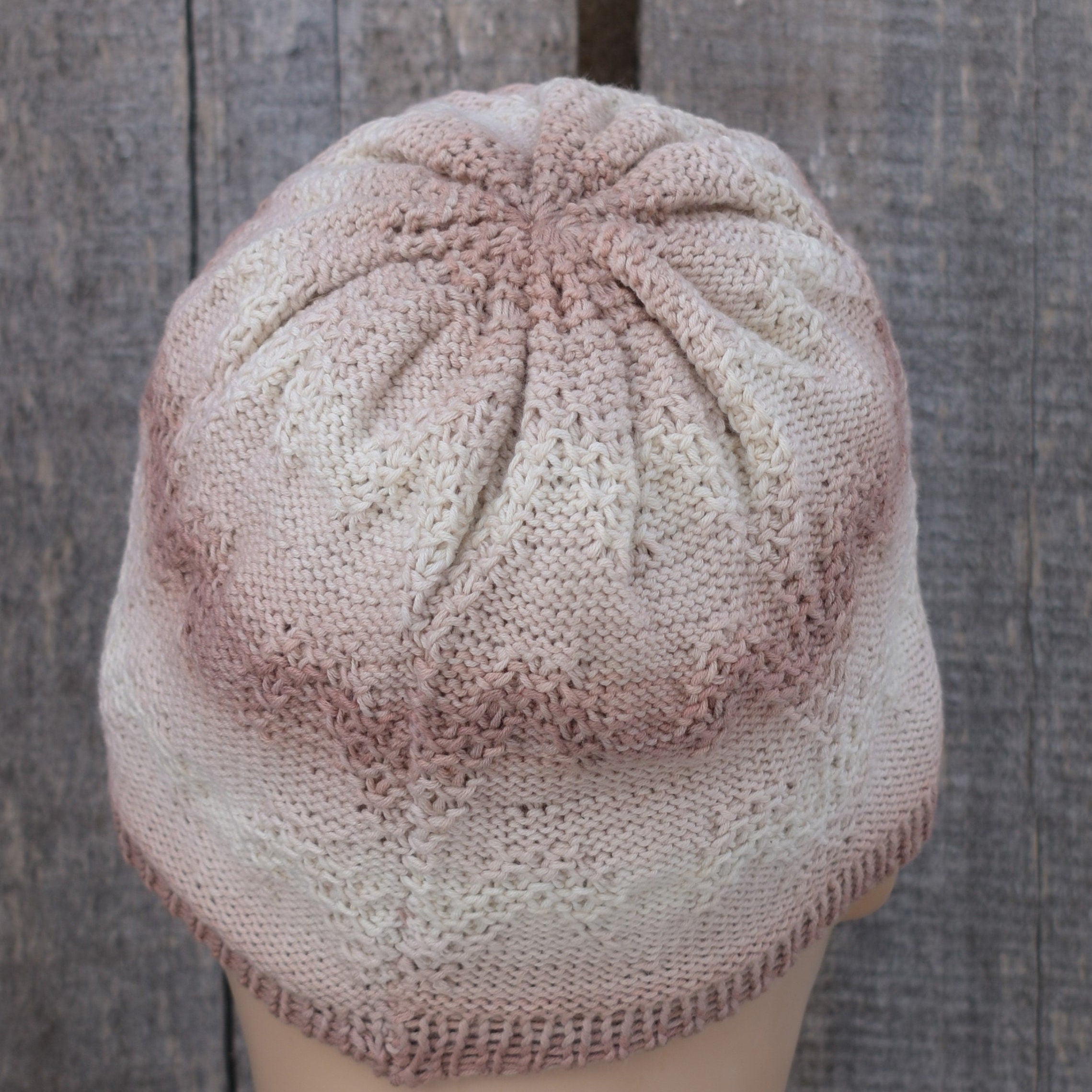 Knitted cap on a mannequin head against a wooden background