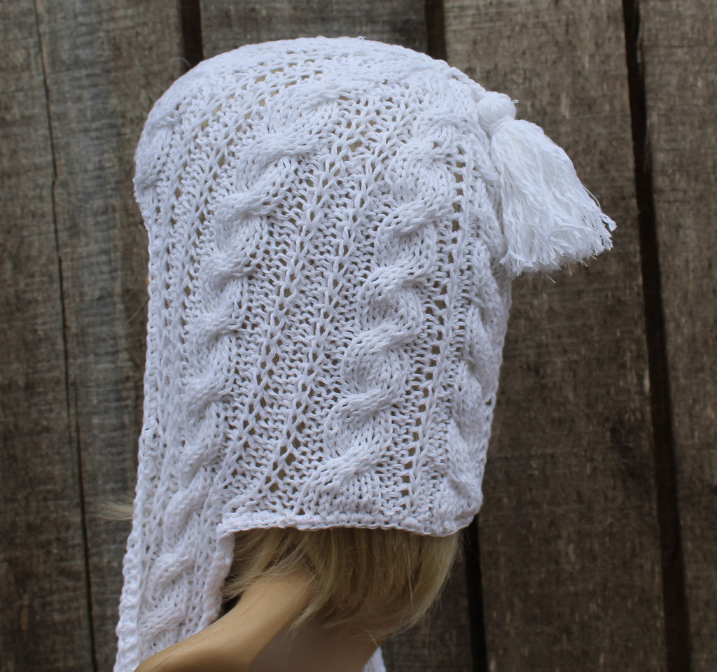 White knitted hood on a mannequin head against a wooden background