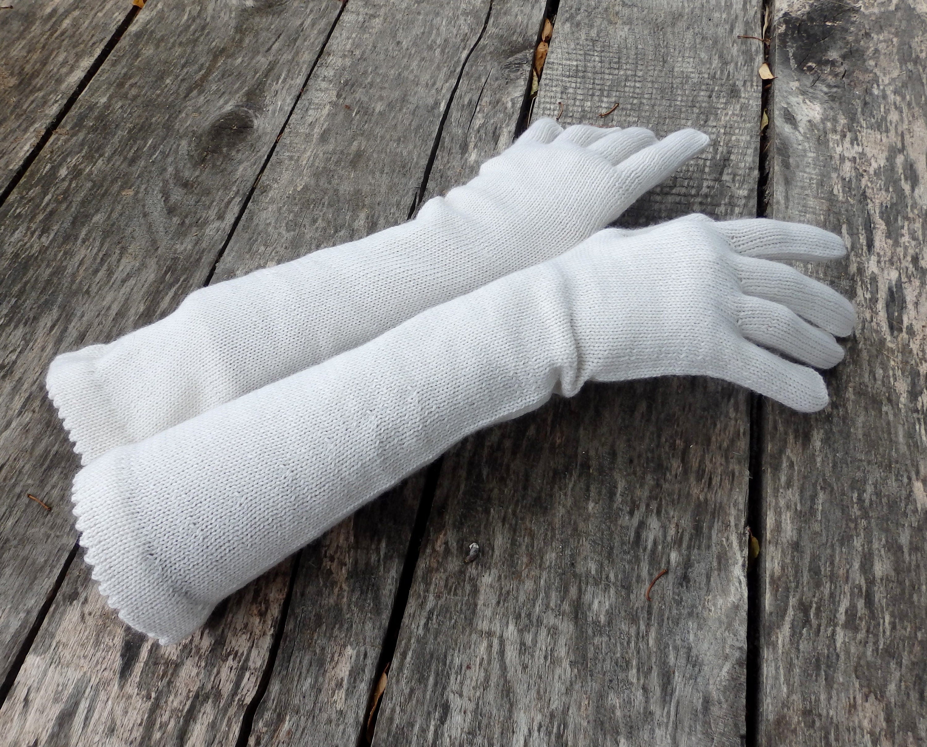 Pair of white gloves on a wooden surface