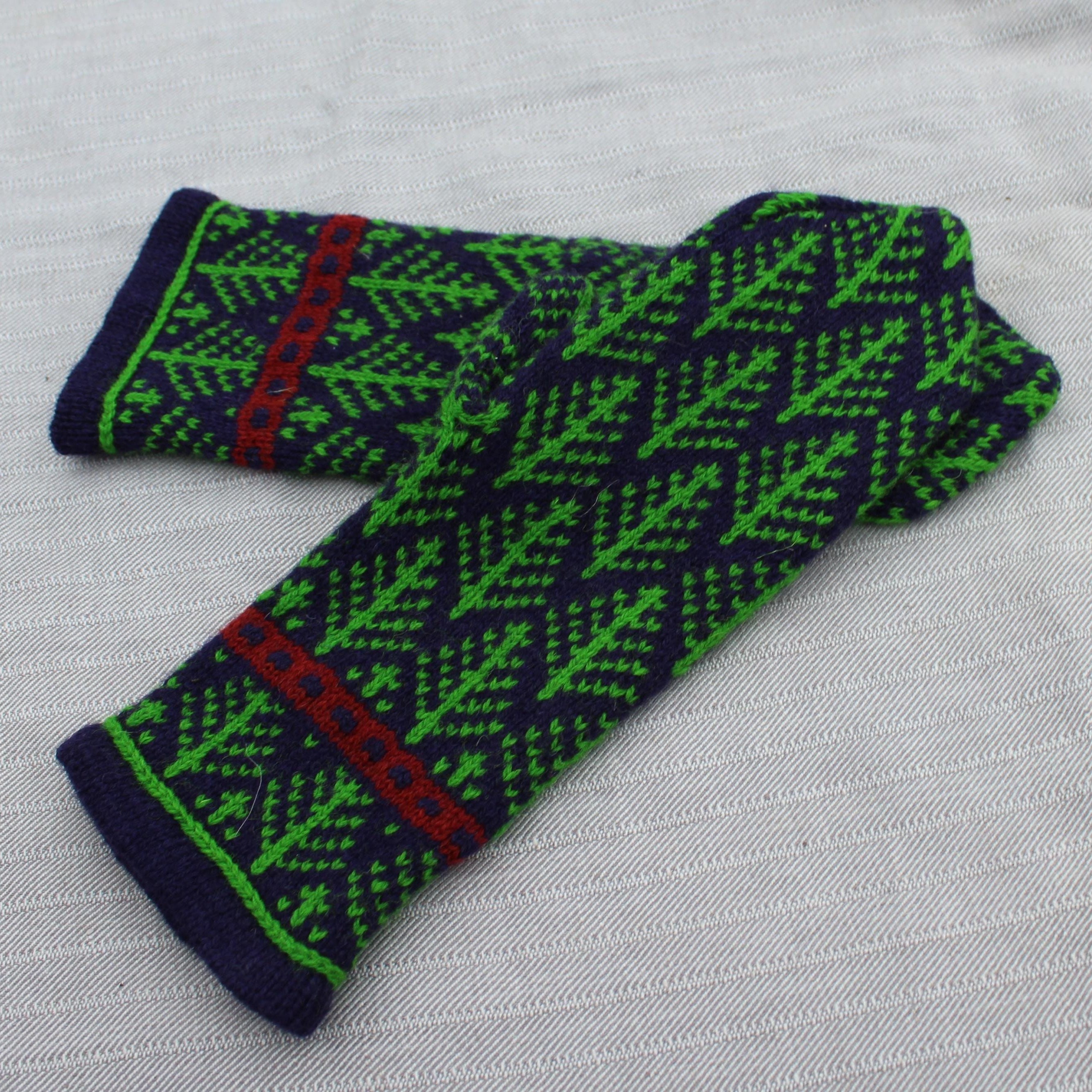 Pair of green and blue patterned fingerless gloves on a light gray background