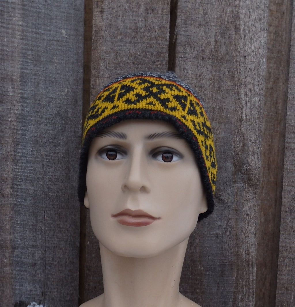Mannequin head wearing a patterned beanie against a wooden background