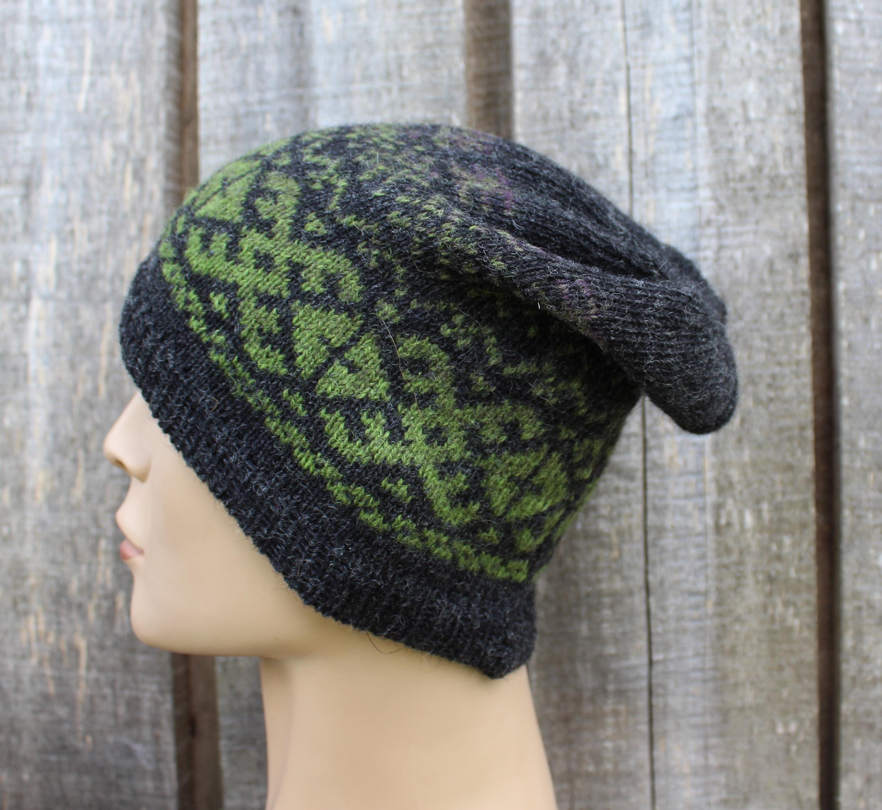 Knitted beanie with green pattern on a wooden background
