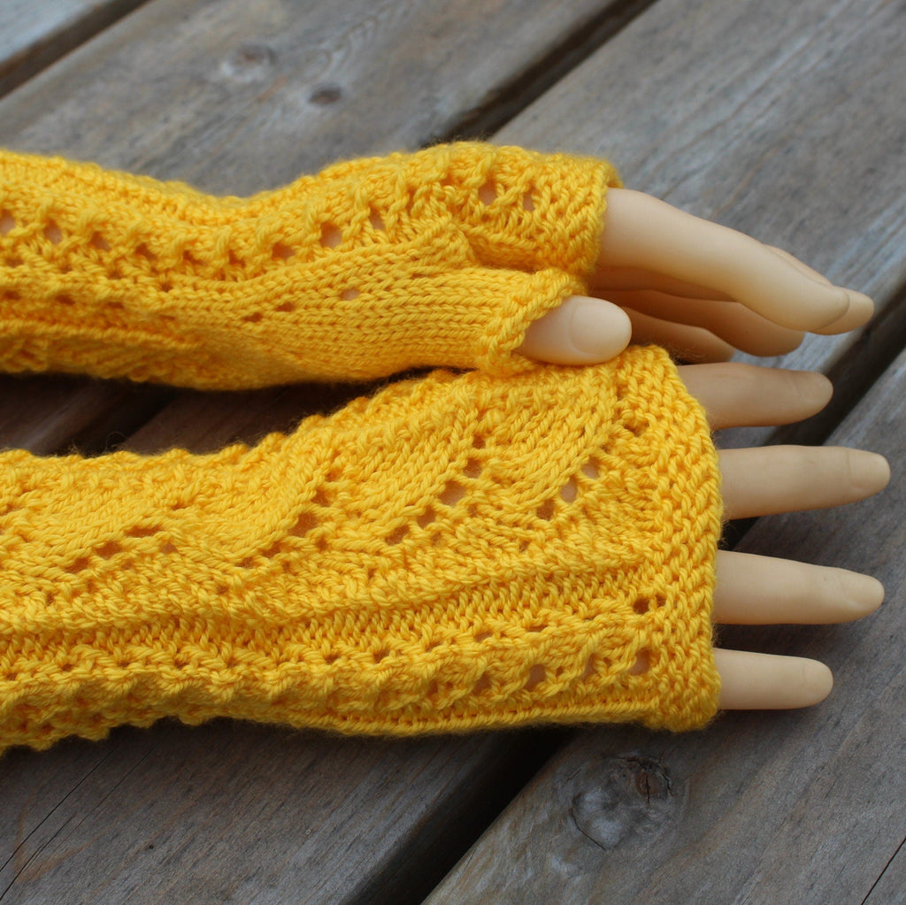 Yellow knitted arm warmers on a wooden surface