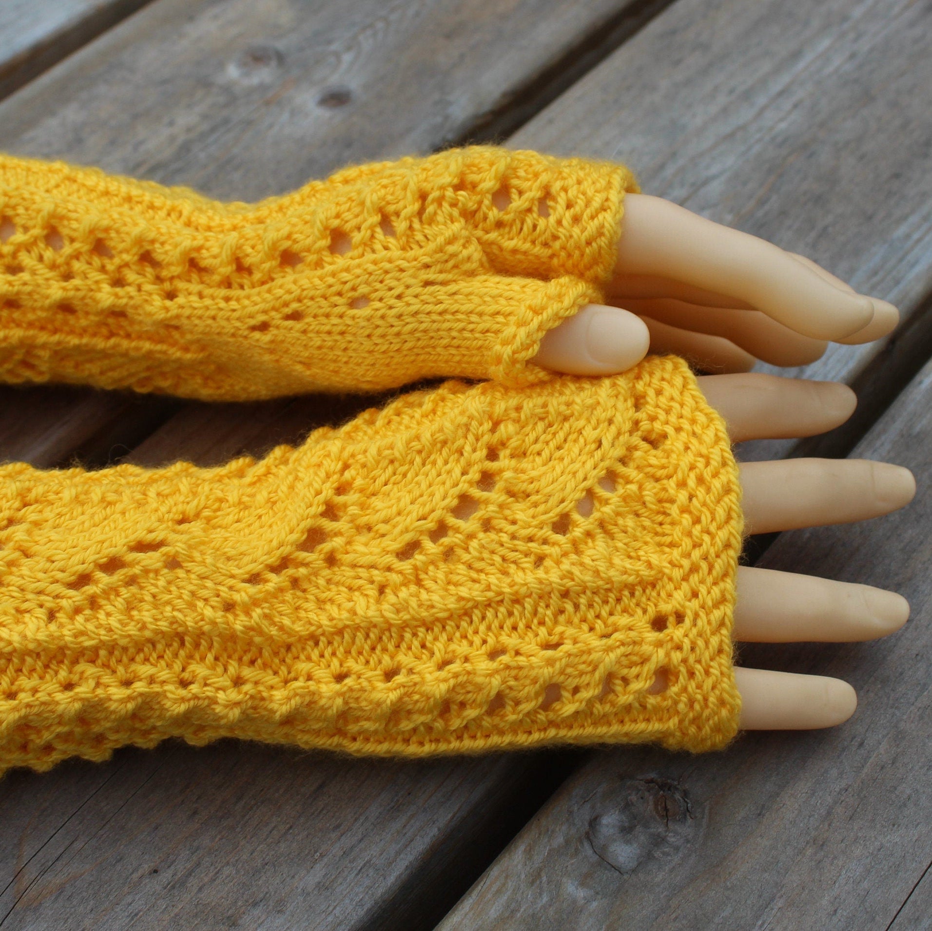 Yellow knitted arm warmers on a wooden surface