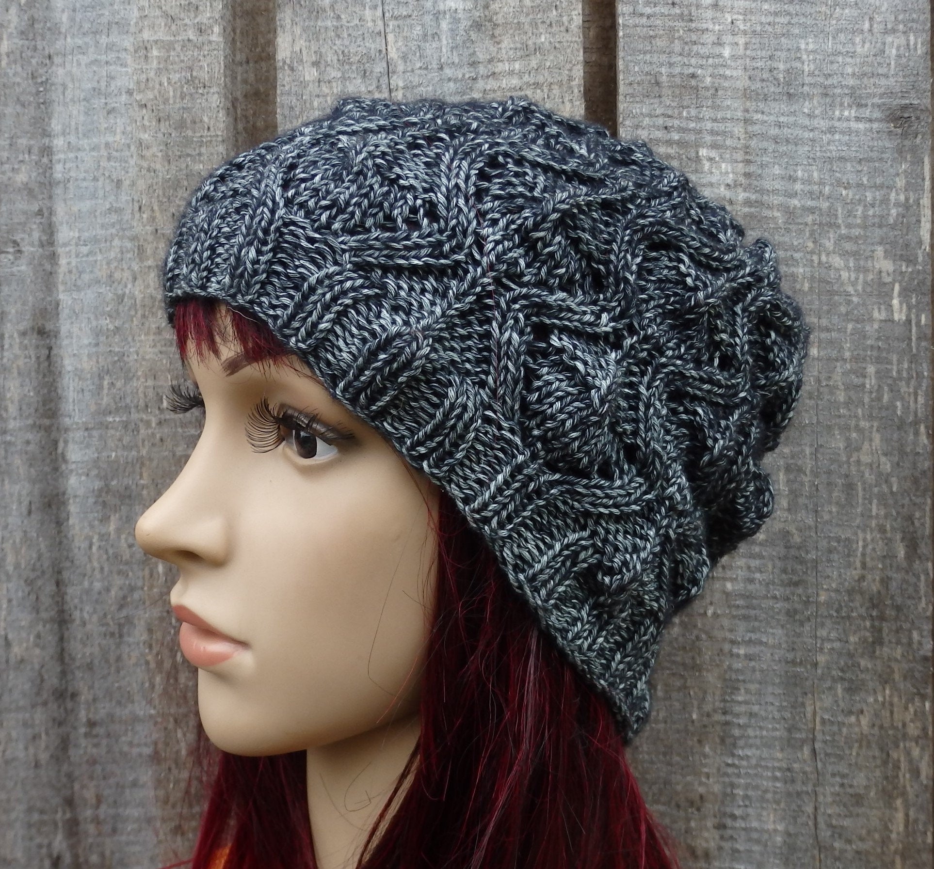 Knitted gray beanie on a mannequin head against a wooden background