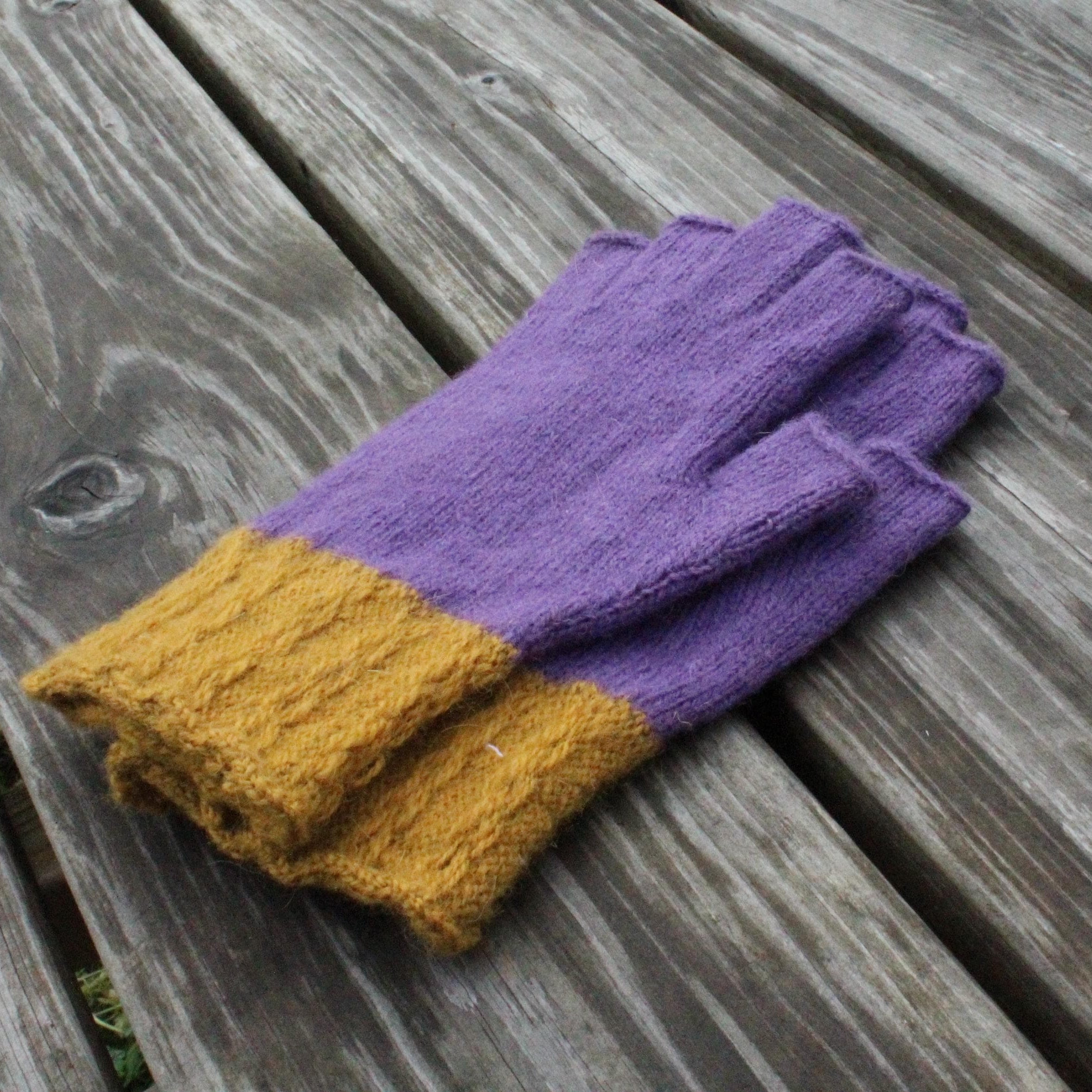 Purple and yellow gloves on a wooden surface