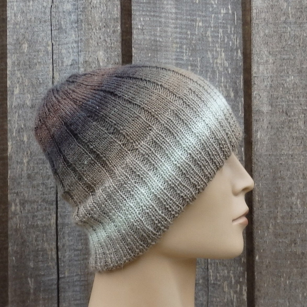 Knitted beanie on a mannequin head against a wooden panel background