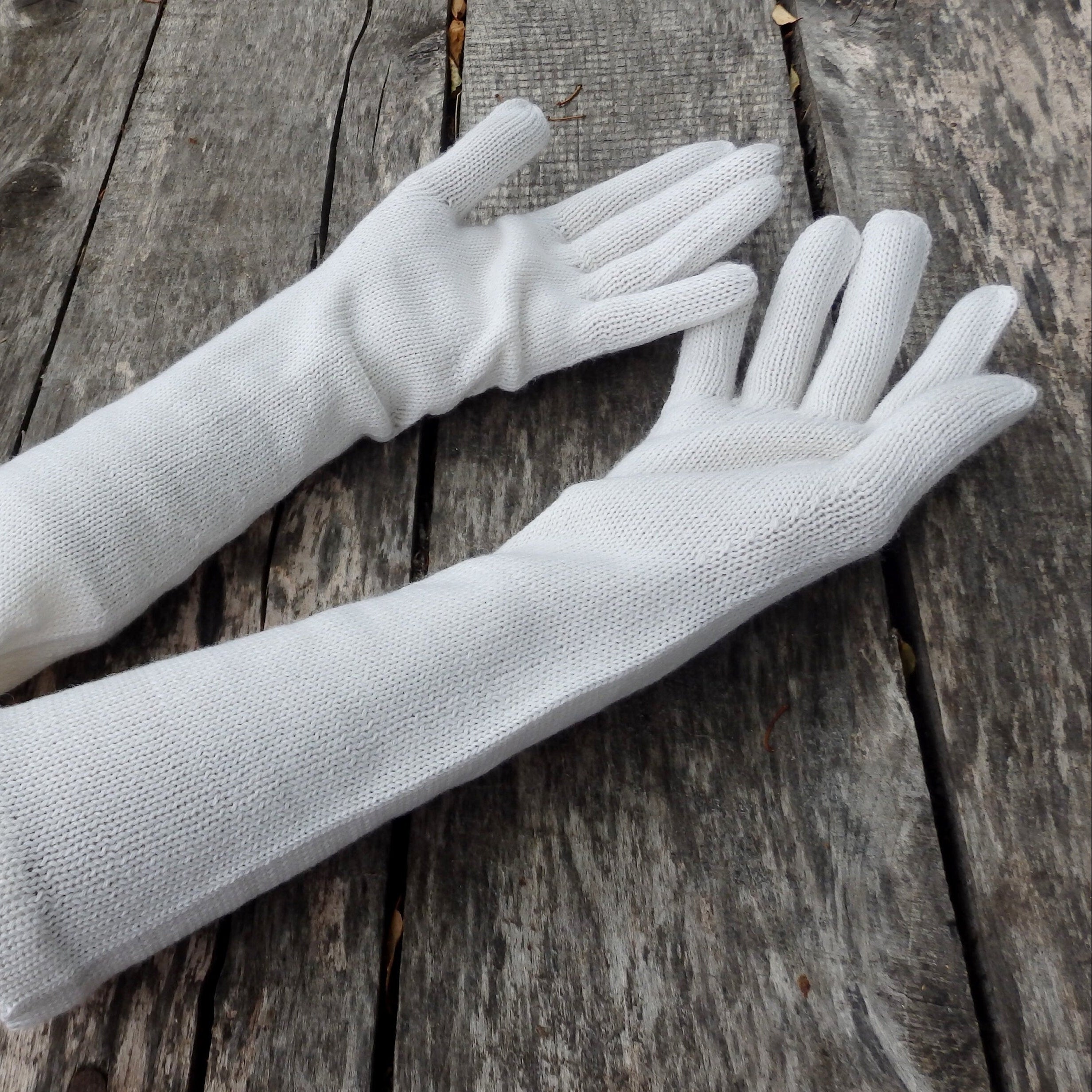 Pair of white gloves on a wooden surface