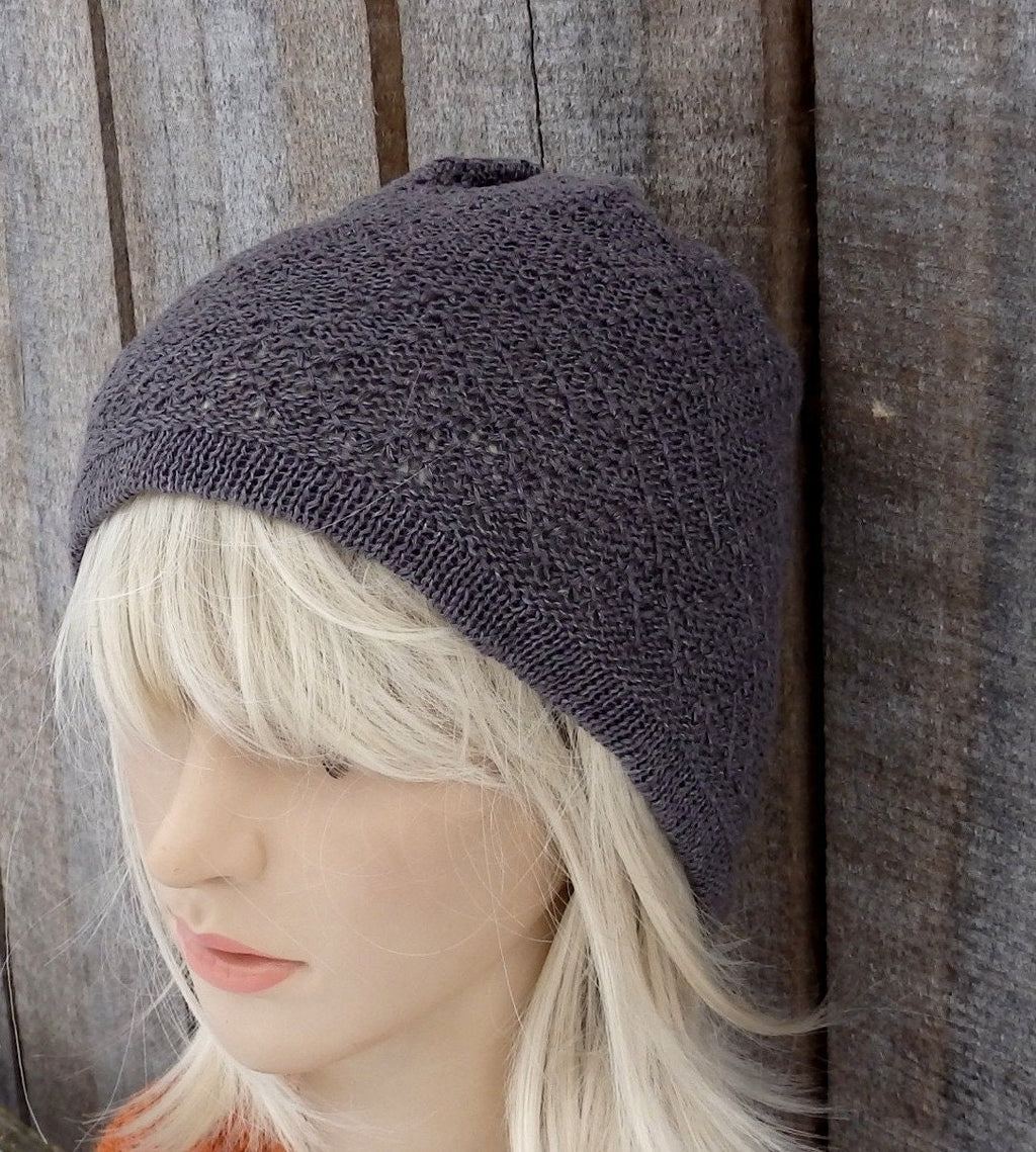 Knitted beanie on a mannequin head against a wooden background