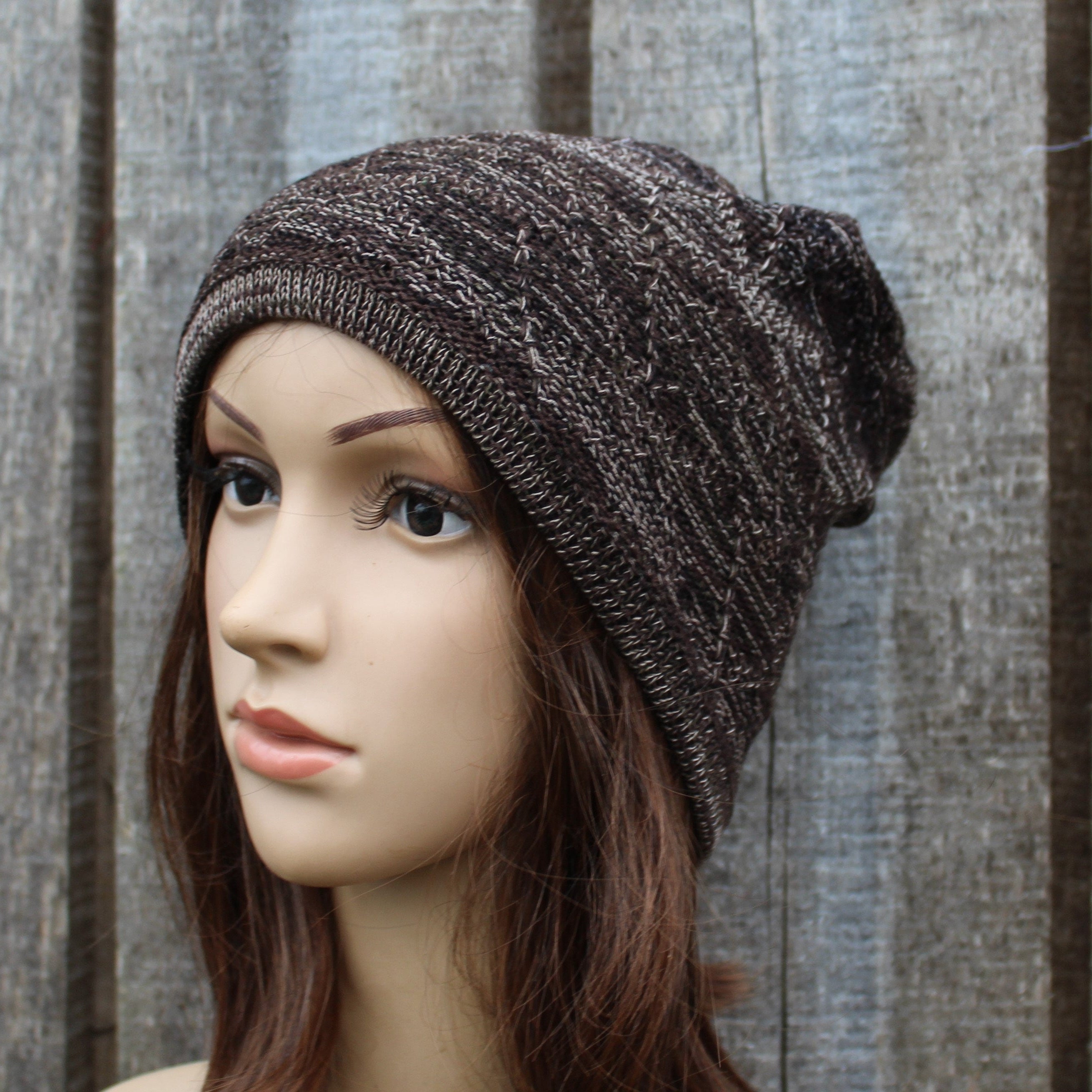 Knitted beanie on a mannequin head against a wooden background