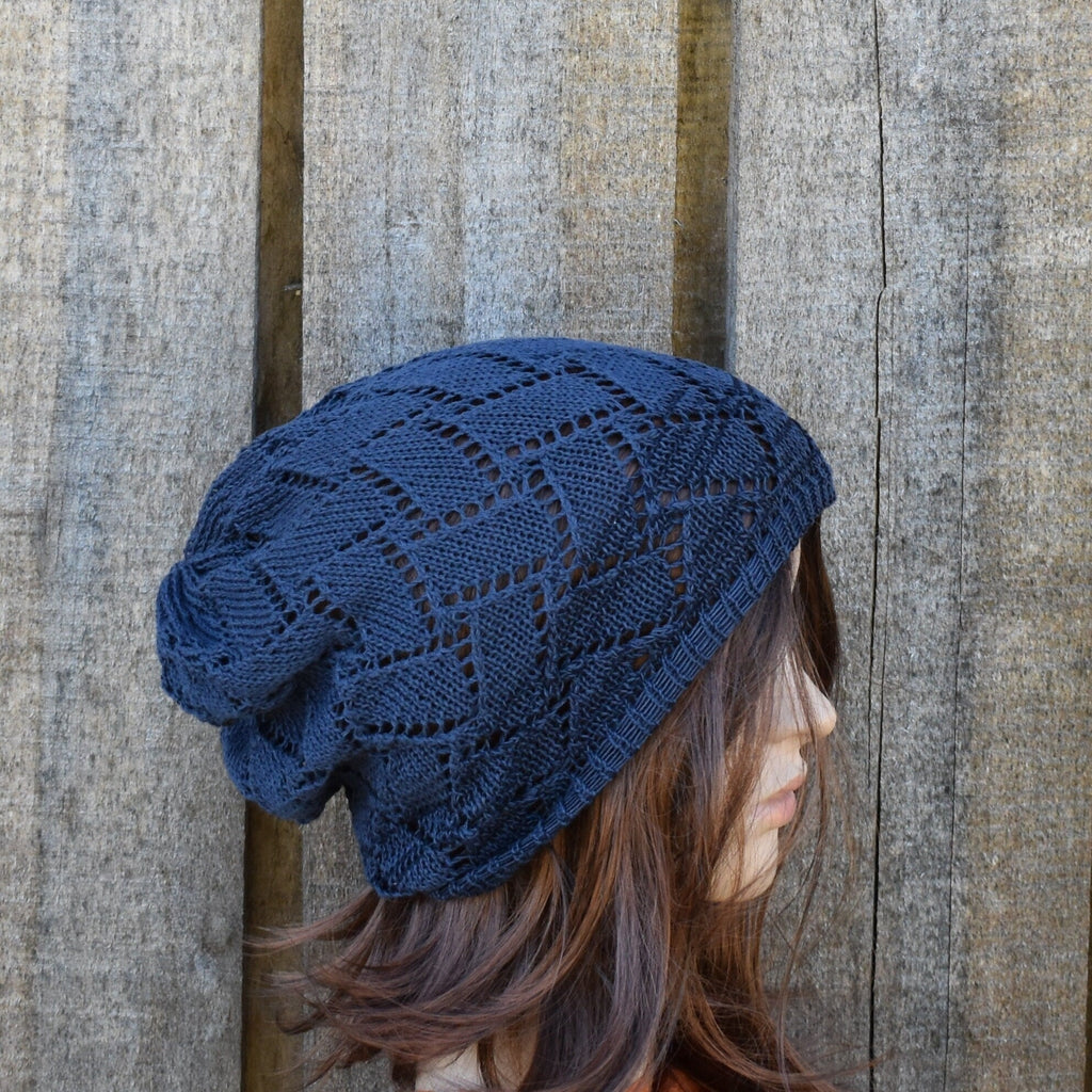 Person wearing a blue knitted slouch hat against a wooden background