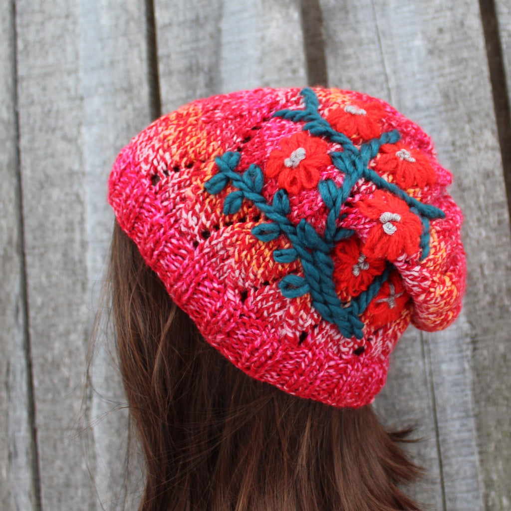 Colorful knitted headband with floral patterns on a wooden surface