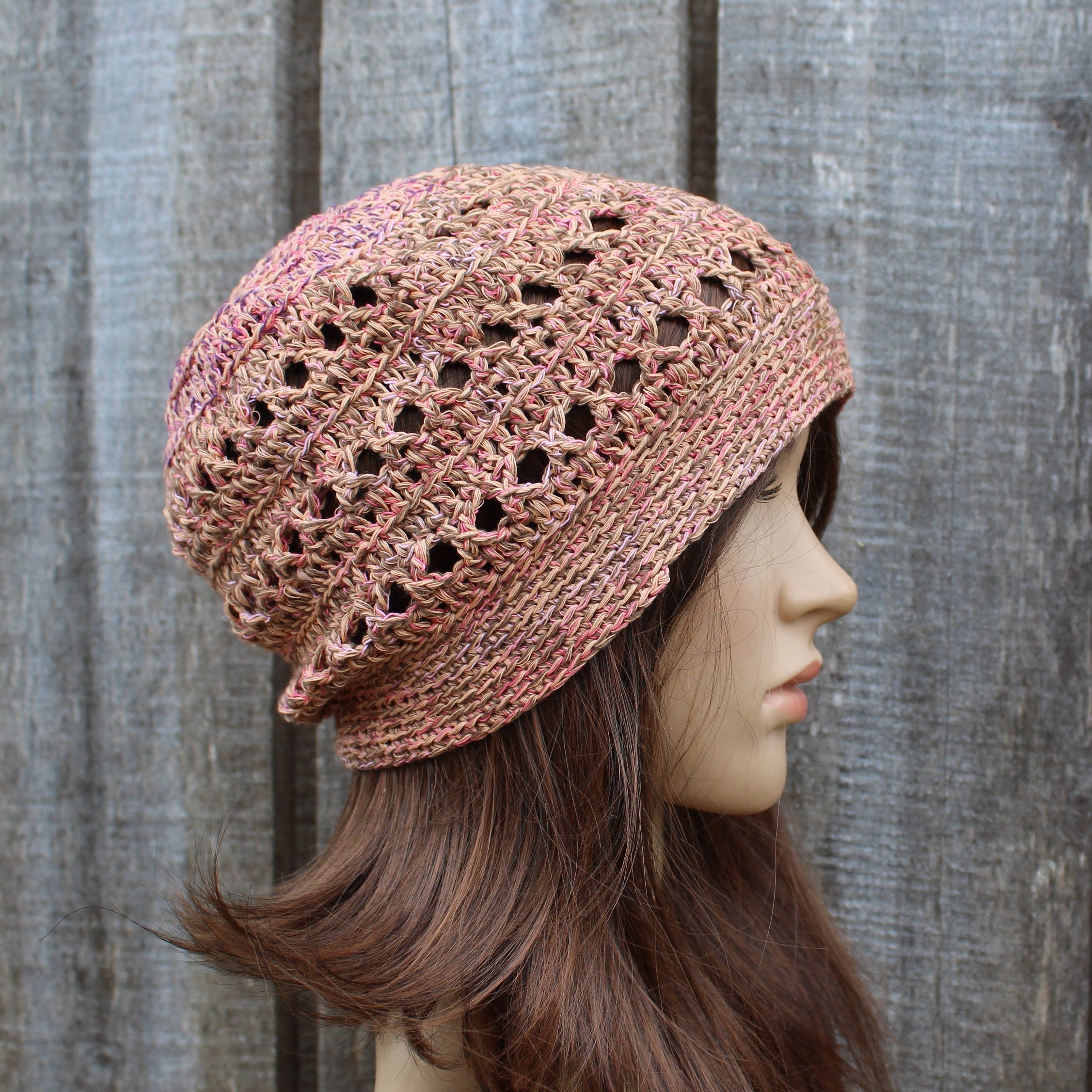 Colorful crochet hat on a mannequin head against a wooden background