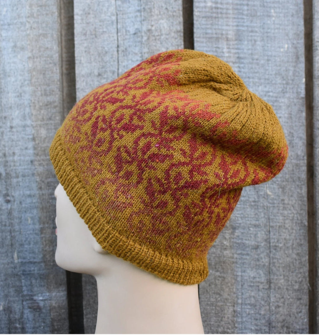 Knitted beanie with a pattern on a mannequin head against a wooden background