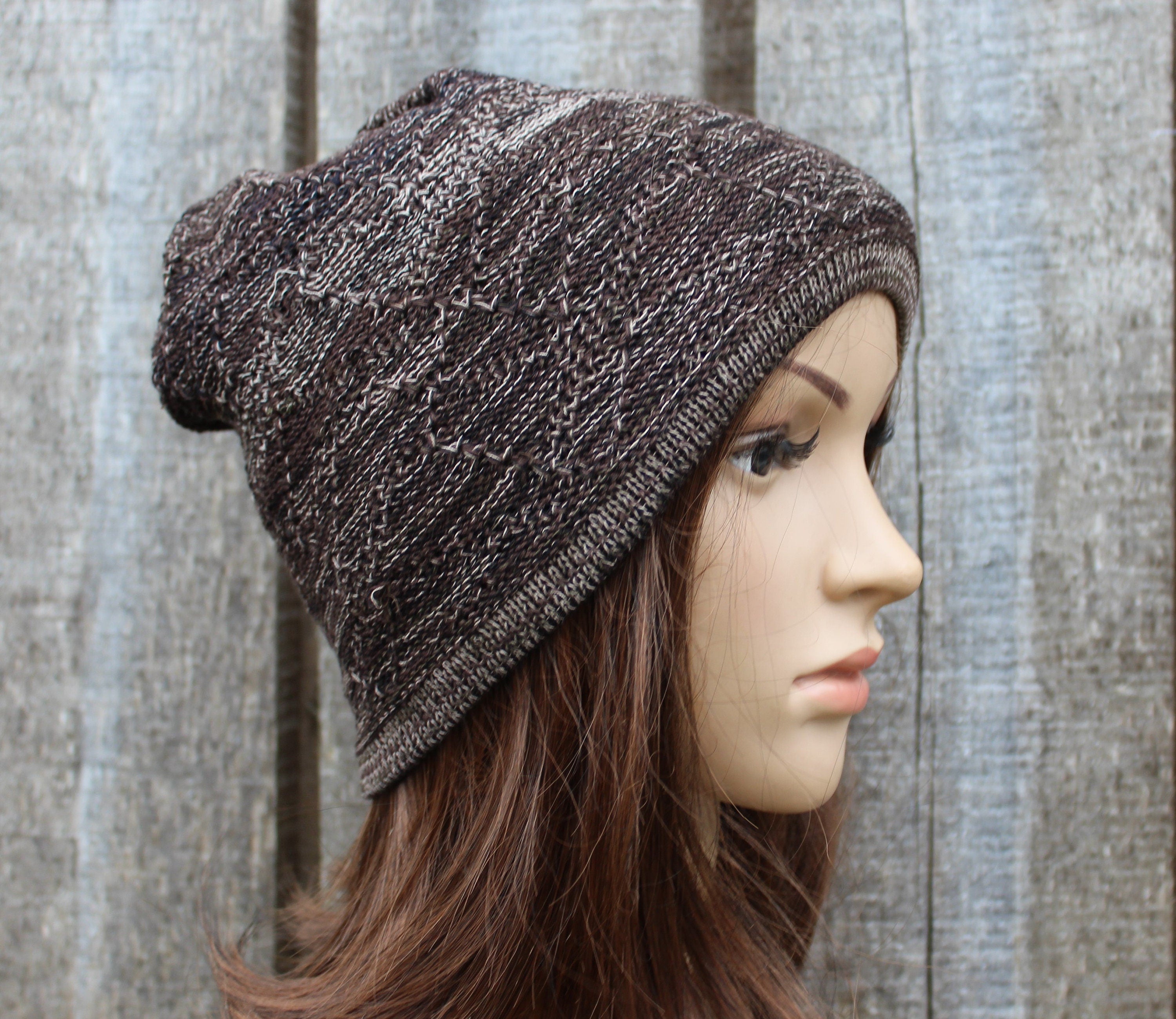 Person wearing a brown knitted beanie against a wooden background