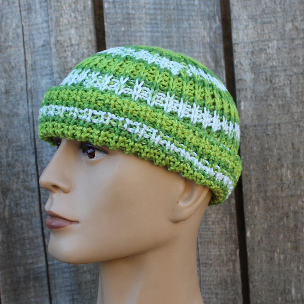 Green and white striped knit beanie on a mannequin head against a wooden background