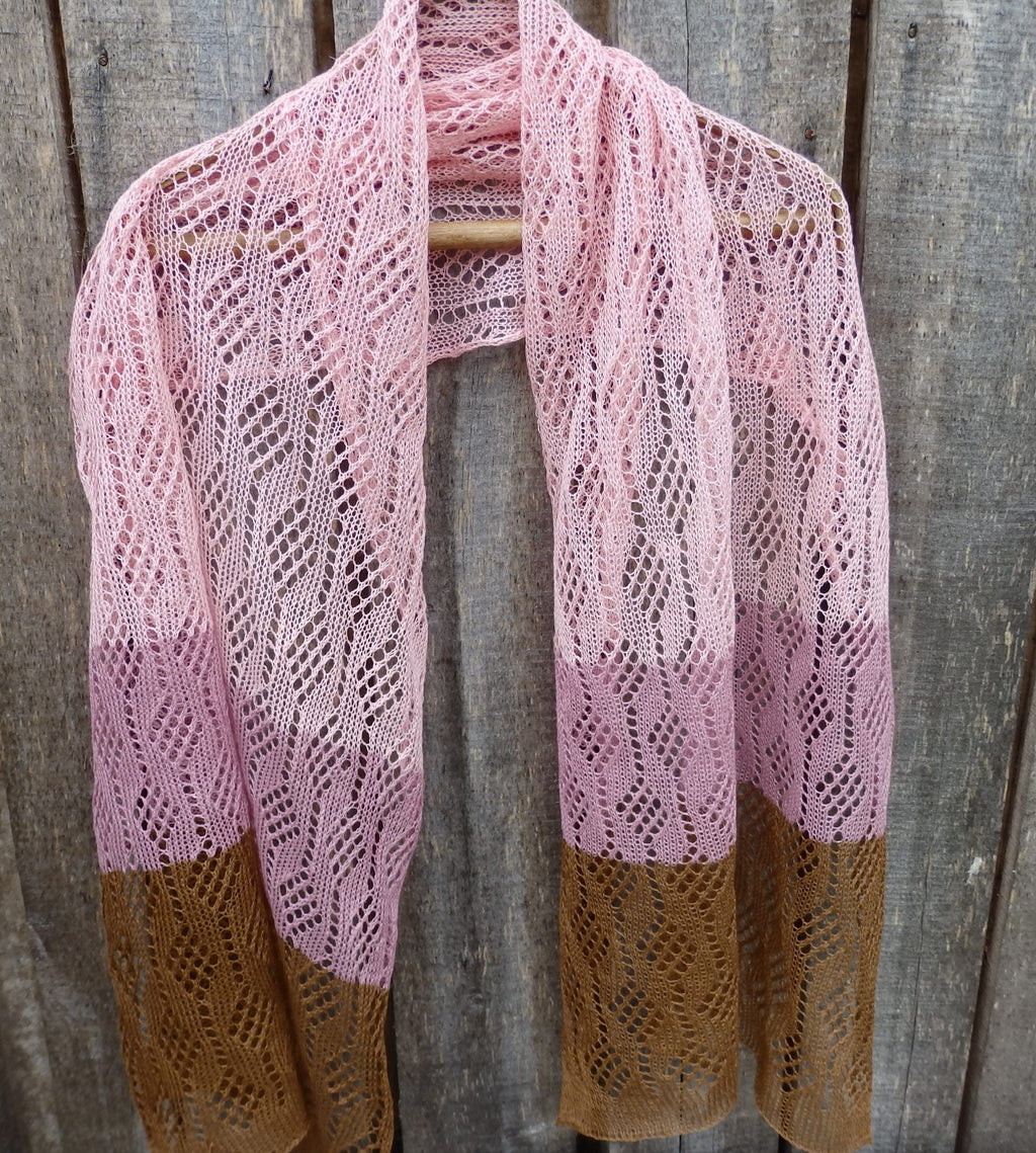 Pink and brown knitted shawl against a wooden background
