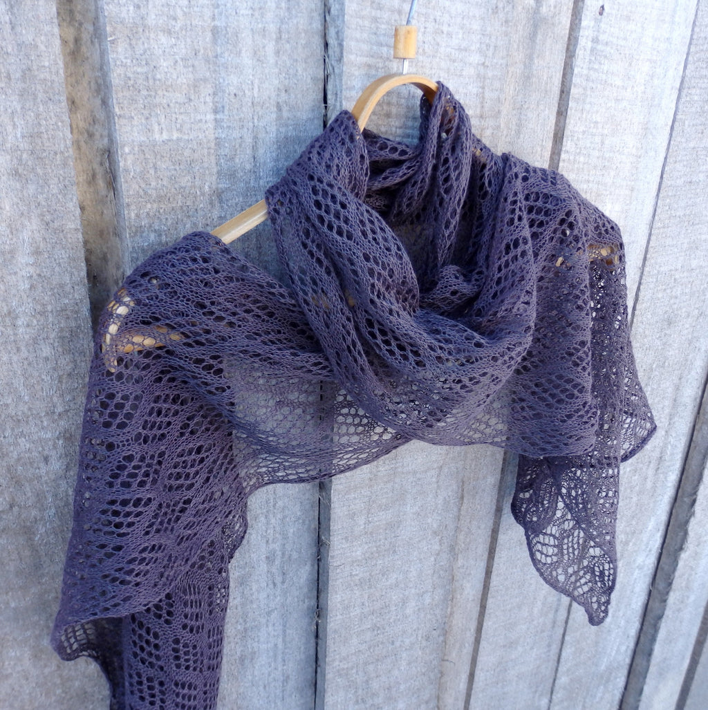 Purple lace scarf on a wooden hanger against a wooden background